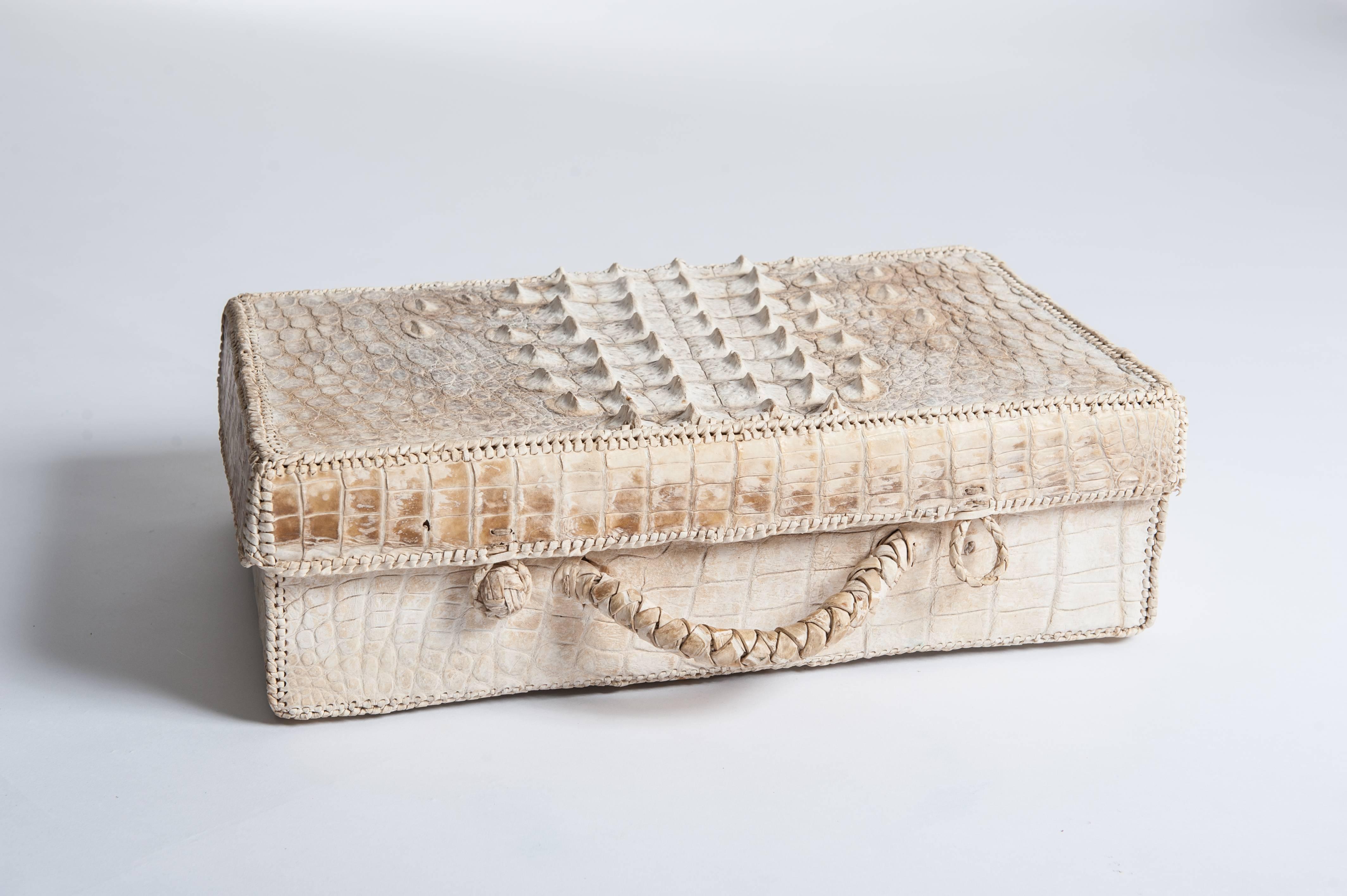 Außergewöhnliche handgefertigte Art Deco Picknicktasche aus Krokoleder mit Hornrücken.
Das Innere des Picknickkoffers ist nicht mehr vorhanden.
Das Objekt ist von Hand zusammengenäht und mit einem feinen Lederband in Creme und Weiß eingefasst,
auch