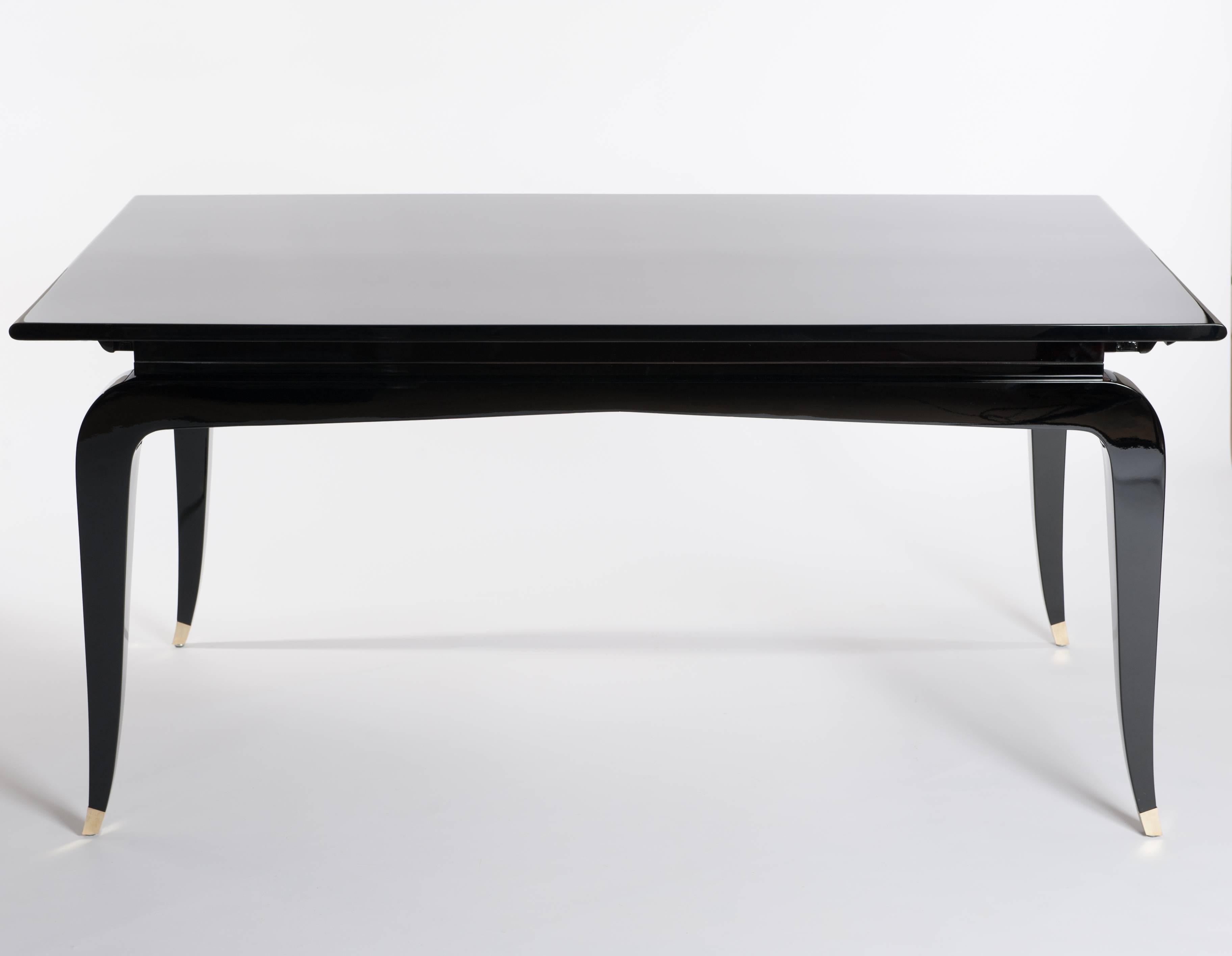 Elegant French Art Deco rectangular dining table (extendable) four tapered legs with bronze trimming.
New Restauration with high gloss shiny-black lacquer on Mahogany wood.
Measure: Extendable with two additional plates to a width of 260cm
Size of