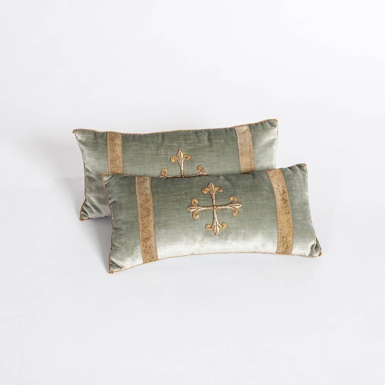 A pair of down-filled pillows fabricated with a 18th century raised gold metallic
embroidery of a cross-bordered with antique gold metallic gallon on pale
French green-grey velvet.
Hand trimmed with vintage gold metallic cording knotted in the
