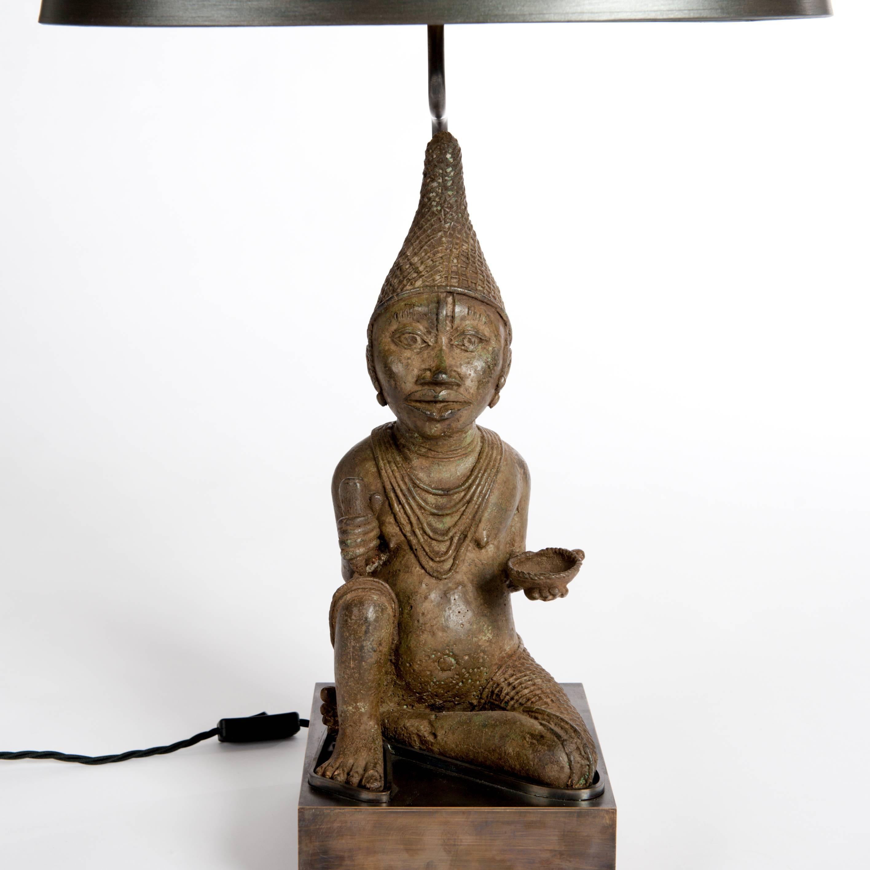 A very fine Mid-Century African Tribal cast bronze from Benin arranged 
with a specially designed lamp construction and socle.
The oval lampshade is hand-painted in green-brown color with fine
overlay of silver powder.

Measurements of the