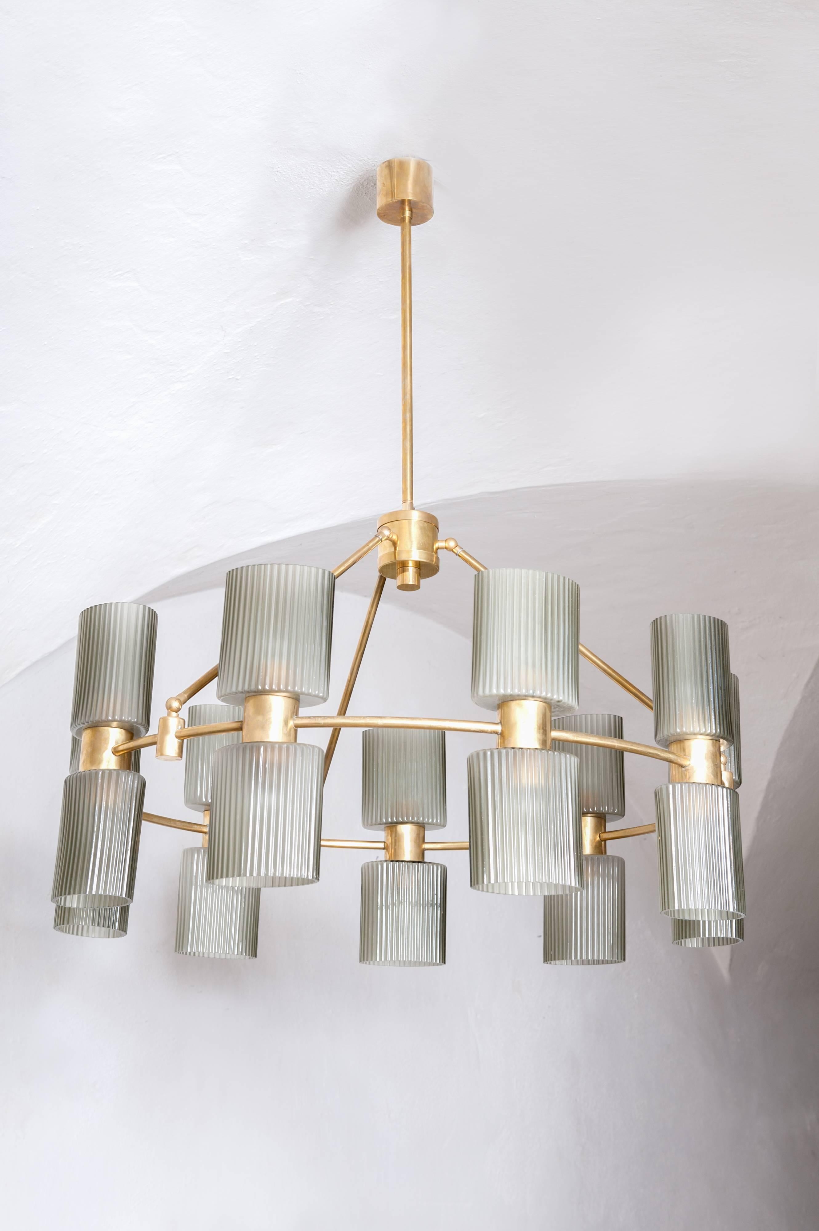 Classical designed lighting object with eighteen-bulb sockets.
The ribbed, grey Murano glass shades are oval shaped on a round brass mounting.
(There are two corresponding wall appliques available, see photo).
