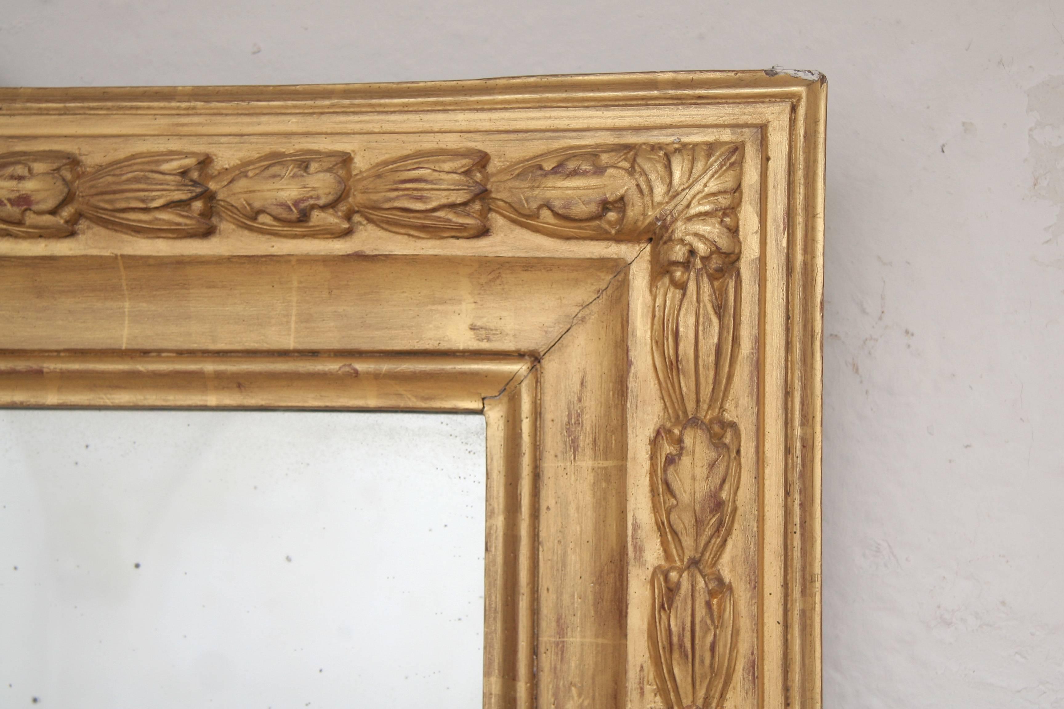Impressive classical wall mirror from Paris represents a carved and gilded wooden frame (15.5cm) with prominent revolving leaf varies.
The original mercury glass makes the object very charming.
(Original wooden back side).
 