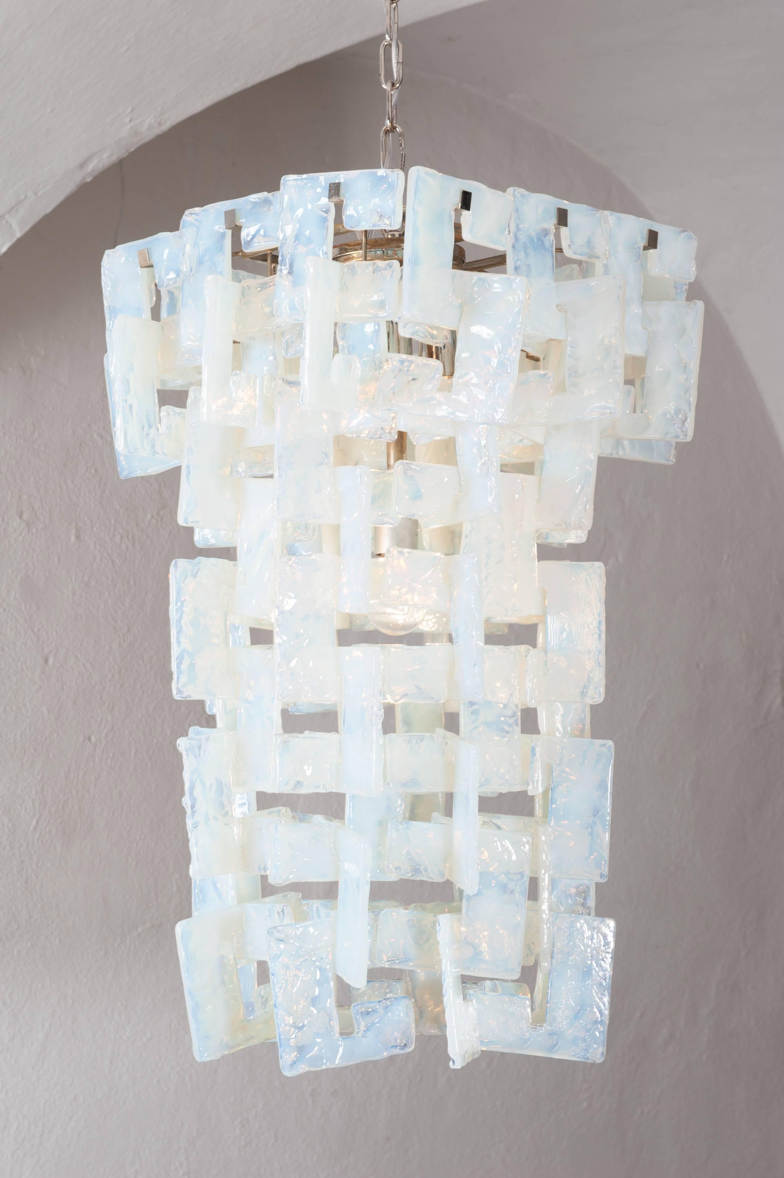 Gorgeous interlocking handblown Murano glass chandelier designed by Carlo Nason for Mazzega. Each Murano glass component is shaped like a C on steel frame with chrome chain and canopy.
The final length depends on the way of hanging the C-shaped,