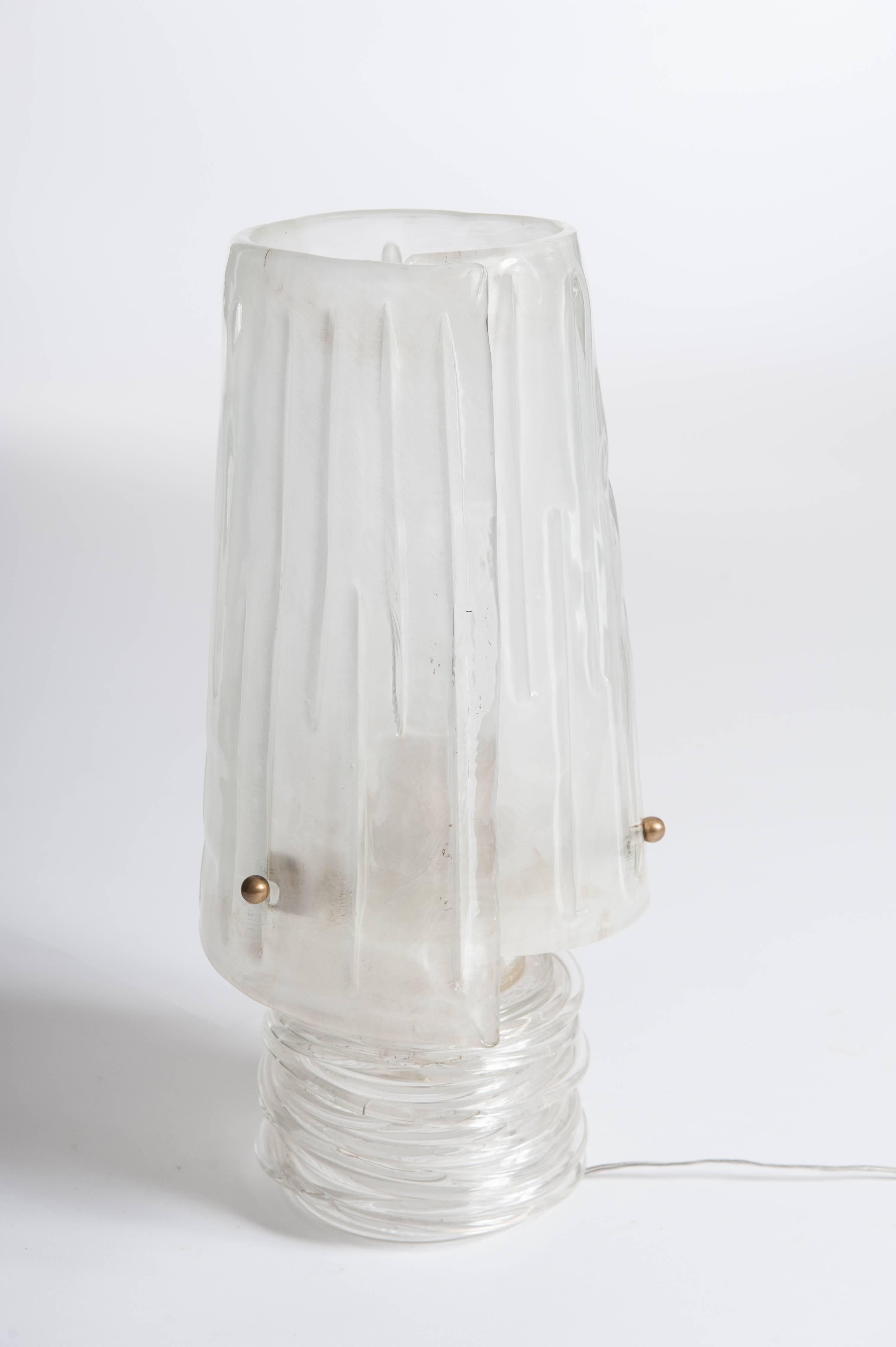 Specially manufactured single piece with clear base worked out of twisted glass layers. 
The translucent shade is reverted like a robe fixed with brass screws.
The transparent glass mass contains fine gold particles which gives the object a very