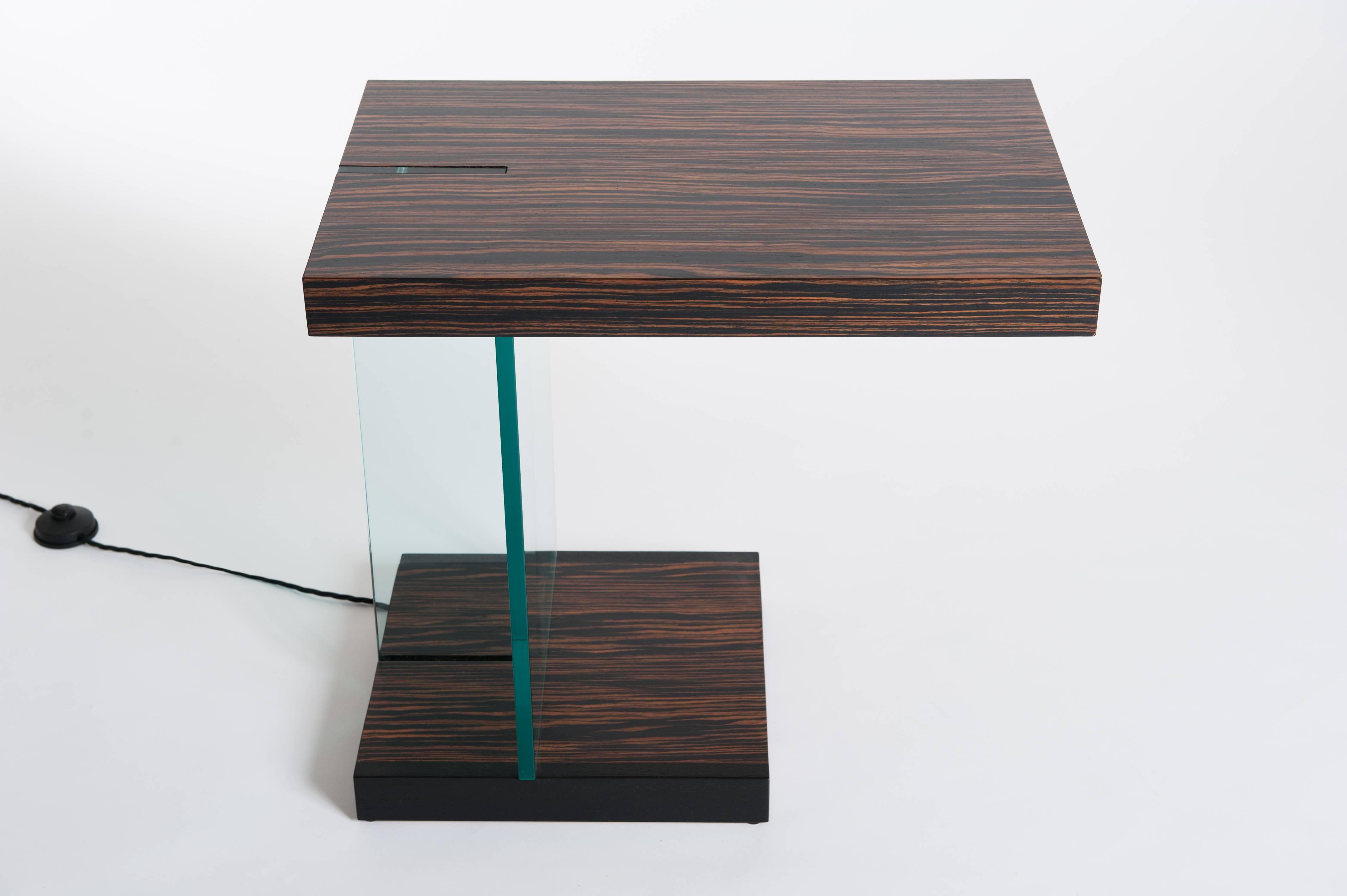 Extraordinary side table or coffee table Zebrawood Veneer and Fontana Arte
glass support. Geometrically shaped design, the glass part can be illuminated
by pressing the foot button.