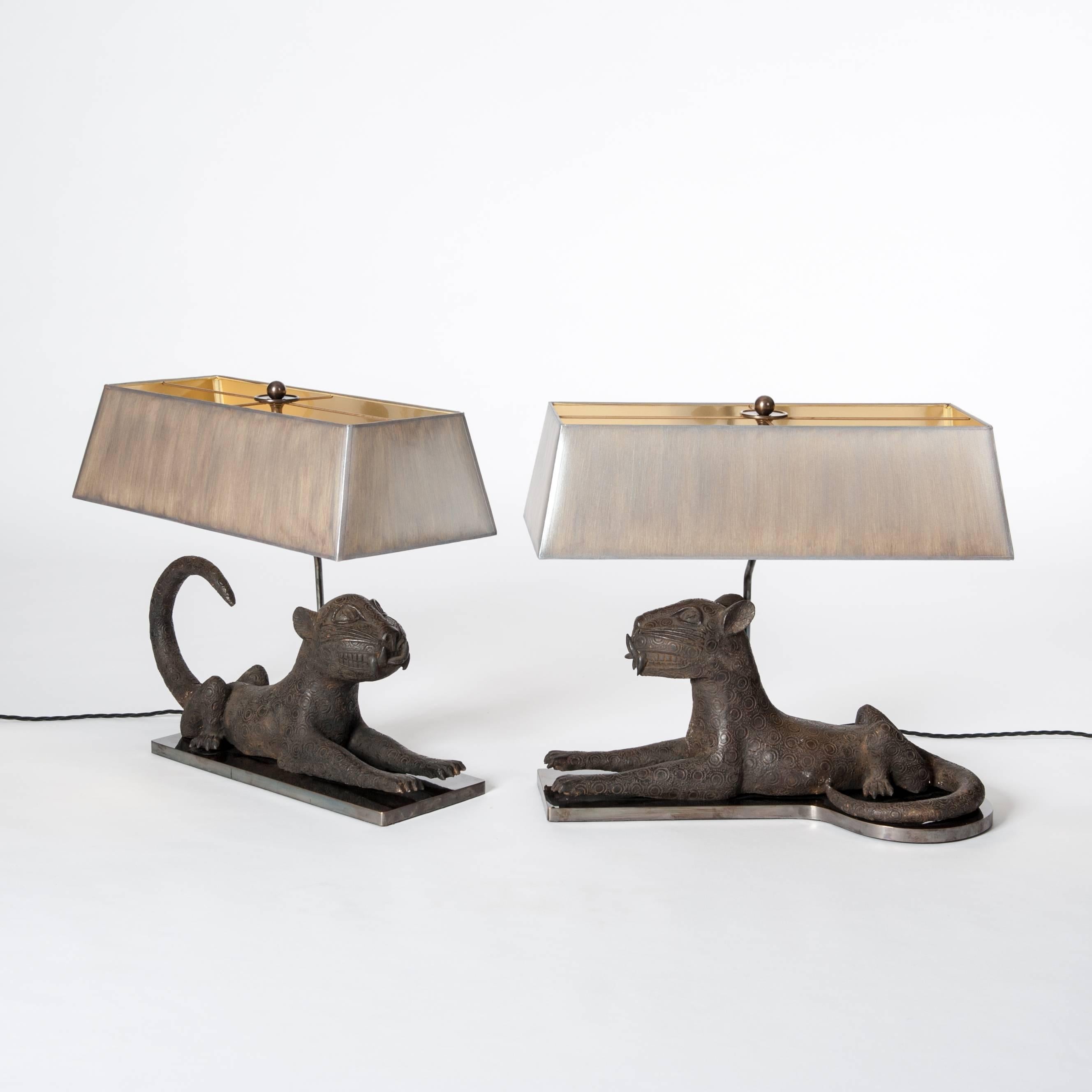 A pair of very fine midcentury cast bronze leopards from Benin arranged with a specially designed lamp construction and socle.
The rectangular lampshades are hand-painted in taupe-grey color with fine overlay in silver powder.
Two-lit