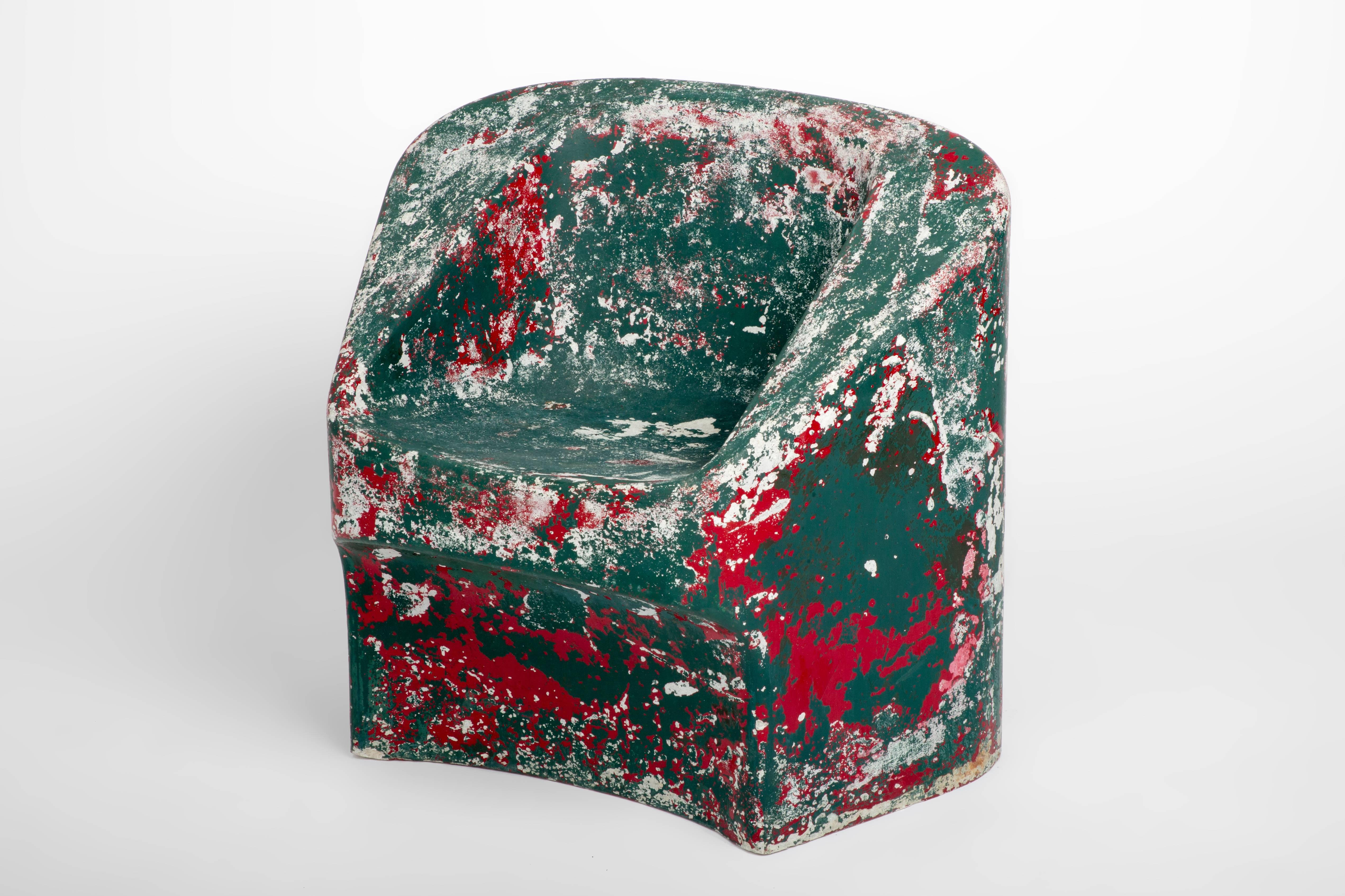 From Swiss designer Willy Guhl this is a fiberglass painted cement chair in distressed green and red hues. Guhl was a creator of innovative and neo-functional furniture, he was also one of the pioneers for flat-pack furniture.