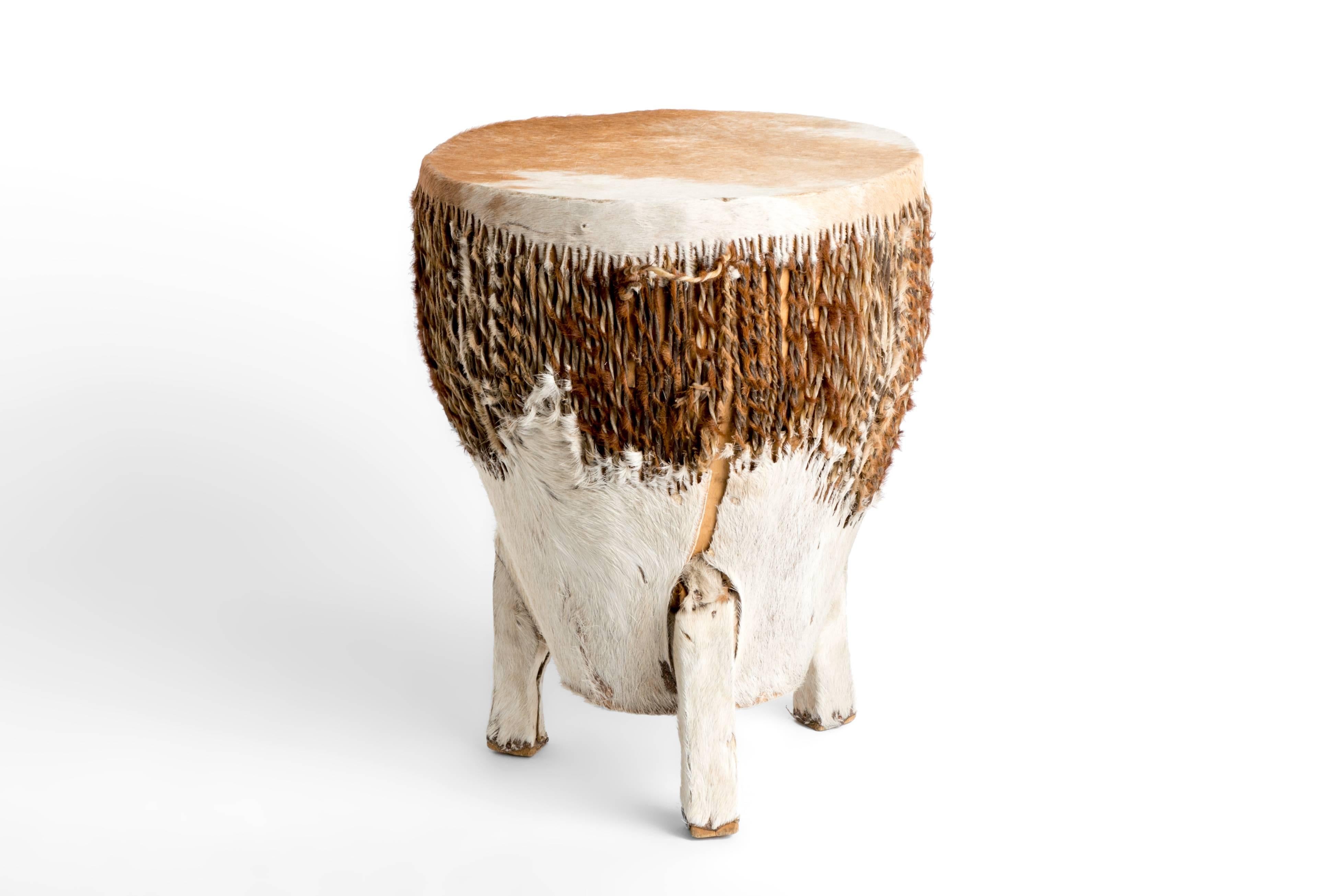Unique brown and white cowhide drum with three feet.