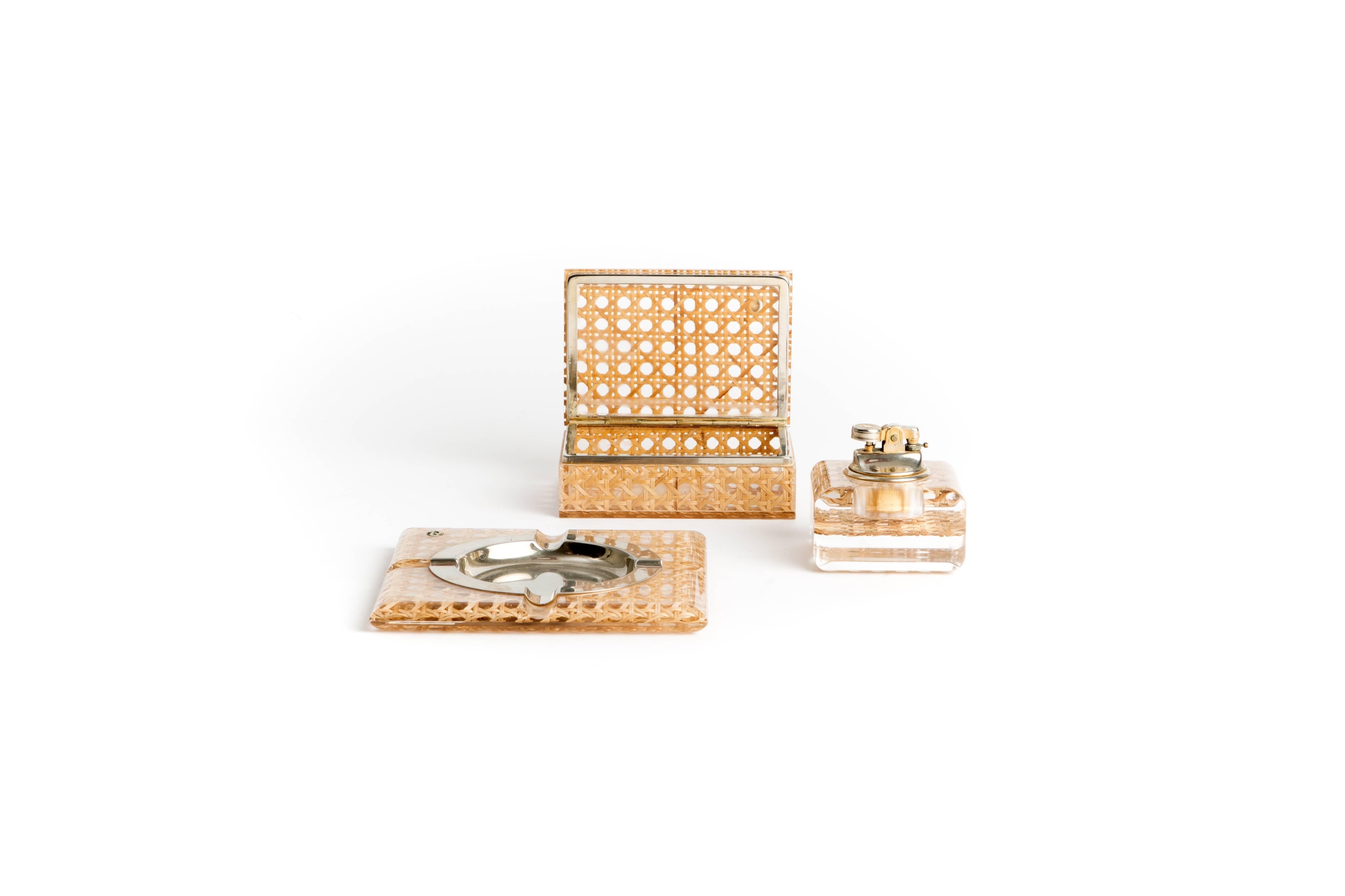 Lucite and wicker smoker set consisting of an ashtray, a cigarette box, and a lighter. Both lighter and ashtray have maker's stamp on the bottom right corner. The lighter has a sticker reading 'designed by Coal for Loreto (An) Italy'

Ashtray