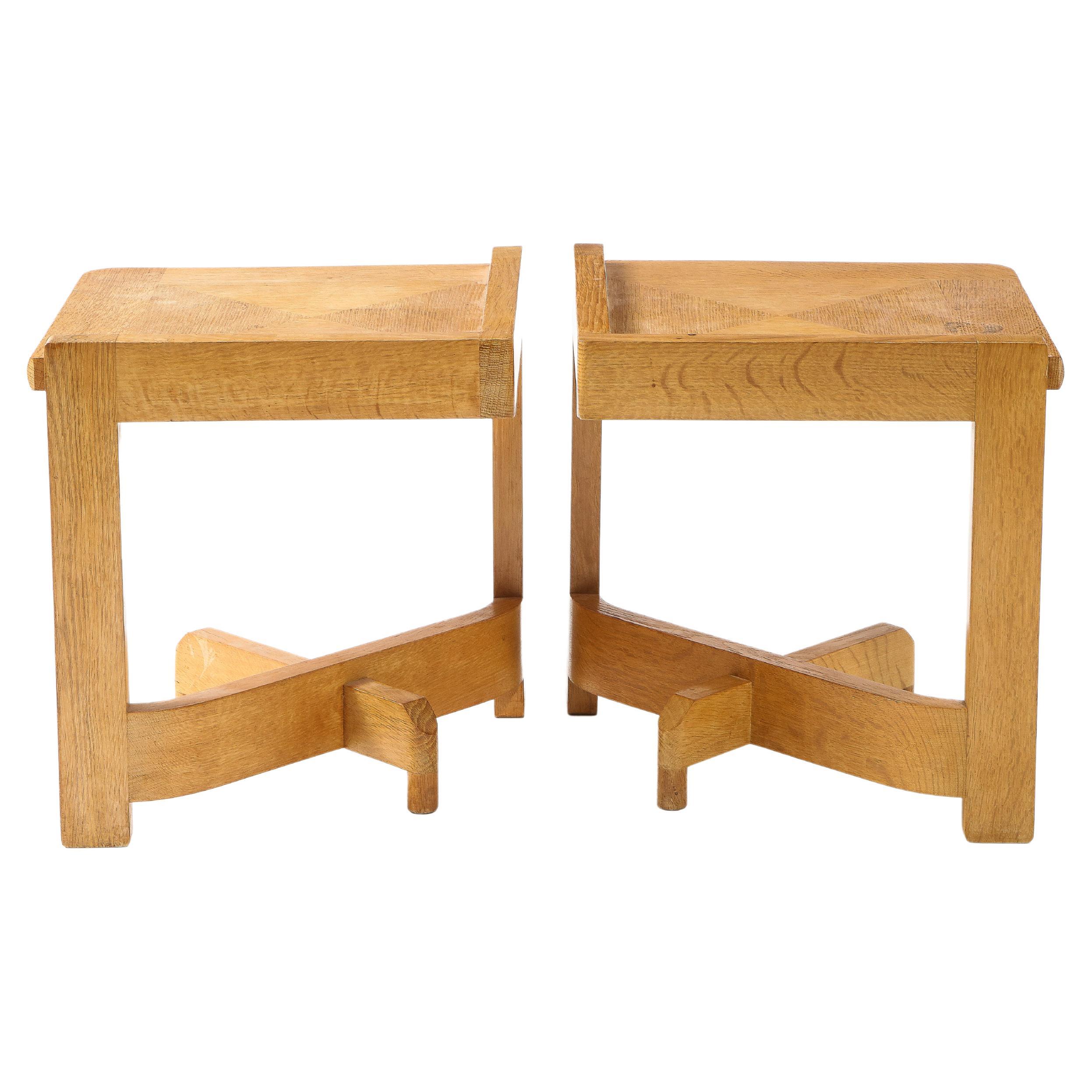 A pair of end tables in oak by Guillerme & Chambron, a very atypical design that rests on asymmetrical legs.