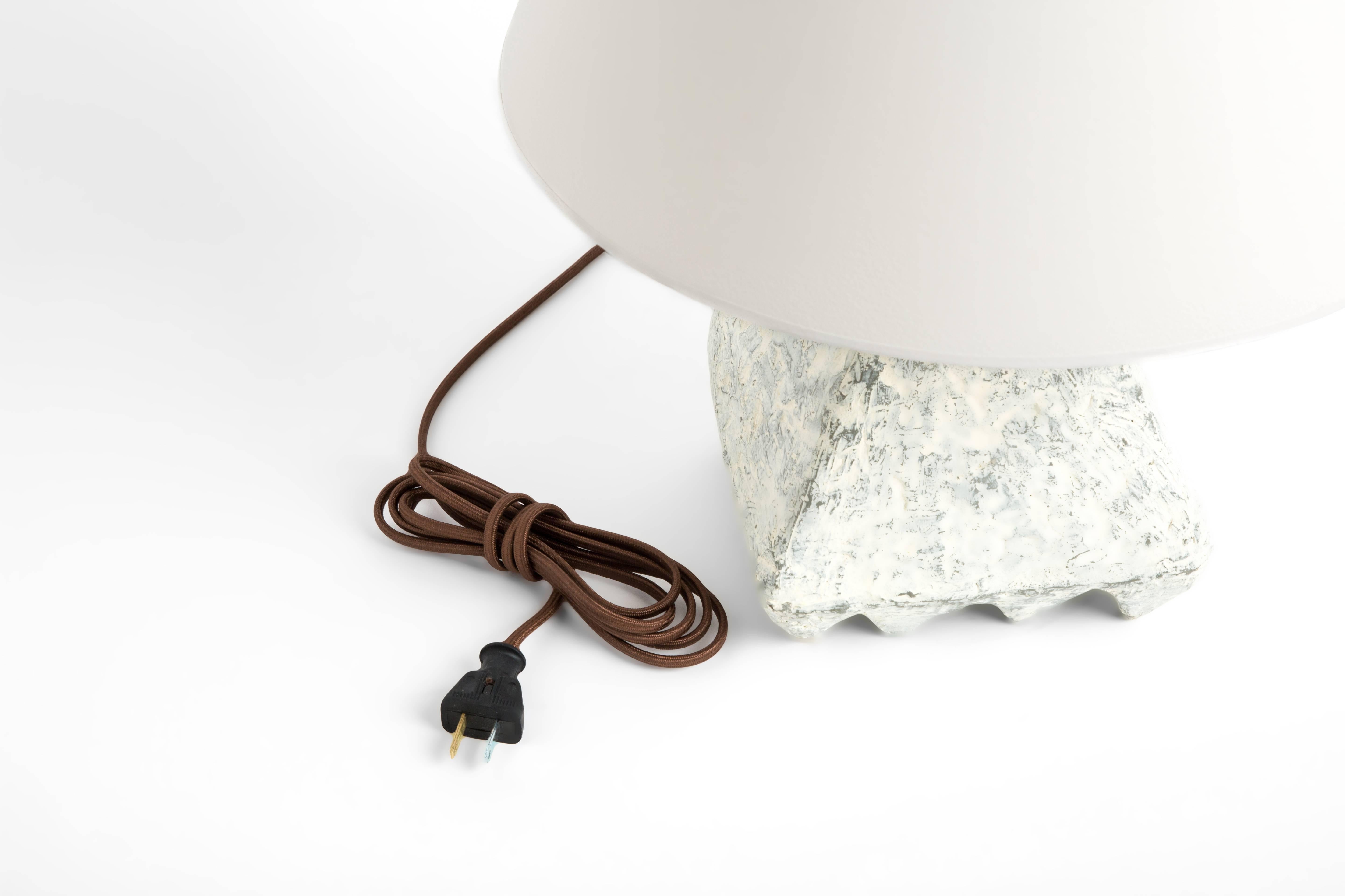 The Cubetto lamp is 1 of 5 resin lamps of Dolatowski's cast lamp series. This resin lamp is organic, modeled and textured in finish and geometric in form. 

Wired to US standards. Shade not included.

Influenced by his travels in Asia and the Middle