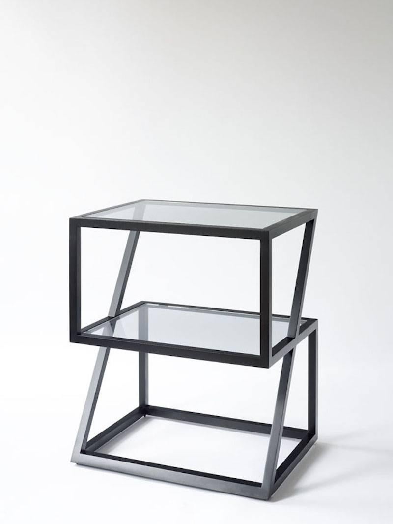 This nightstand is made of blackened steel with inset grey blue glass shelves.