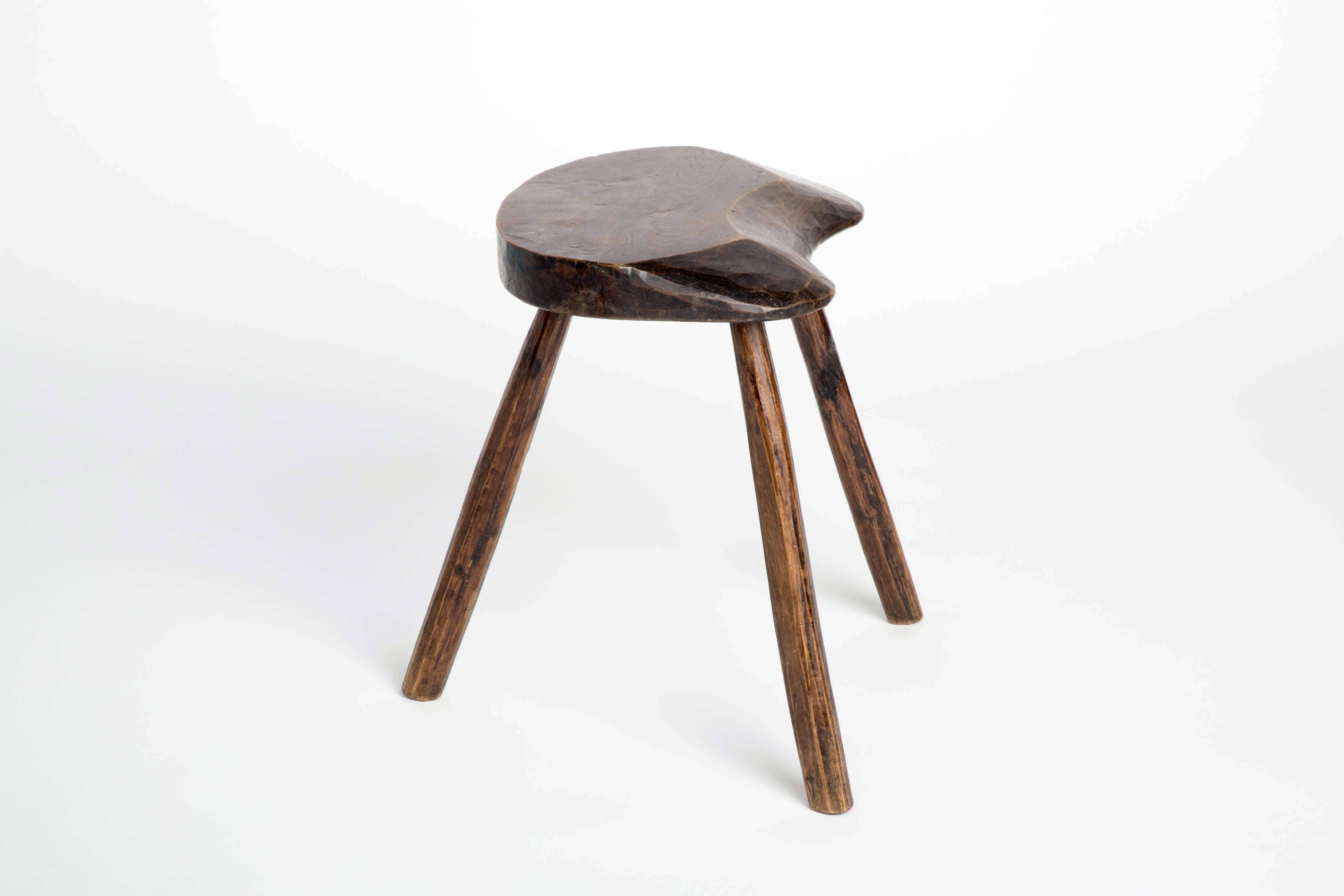 Solid and sturdy dark wood stool with three tripodal splayed legs.

Equally suitable for use as a small side table. 