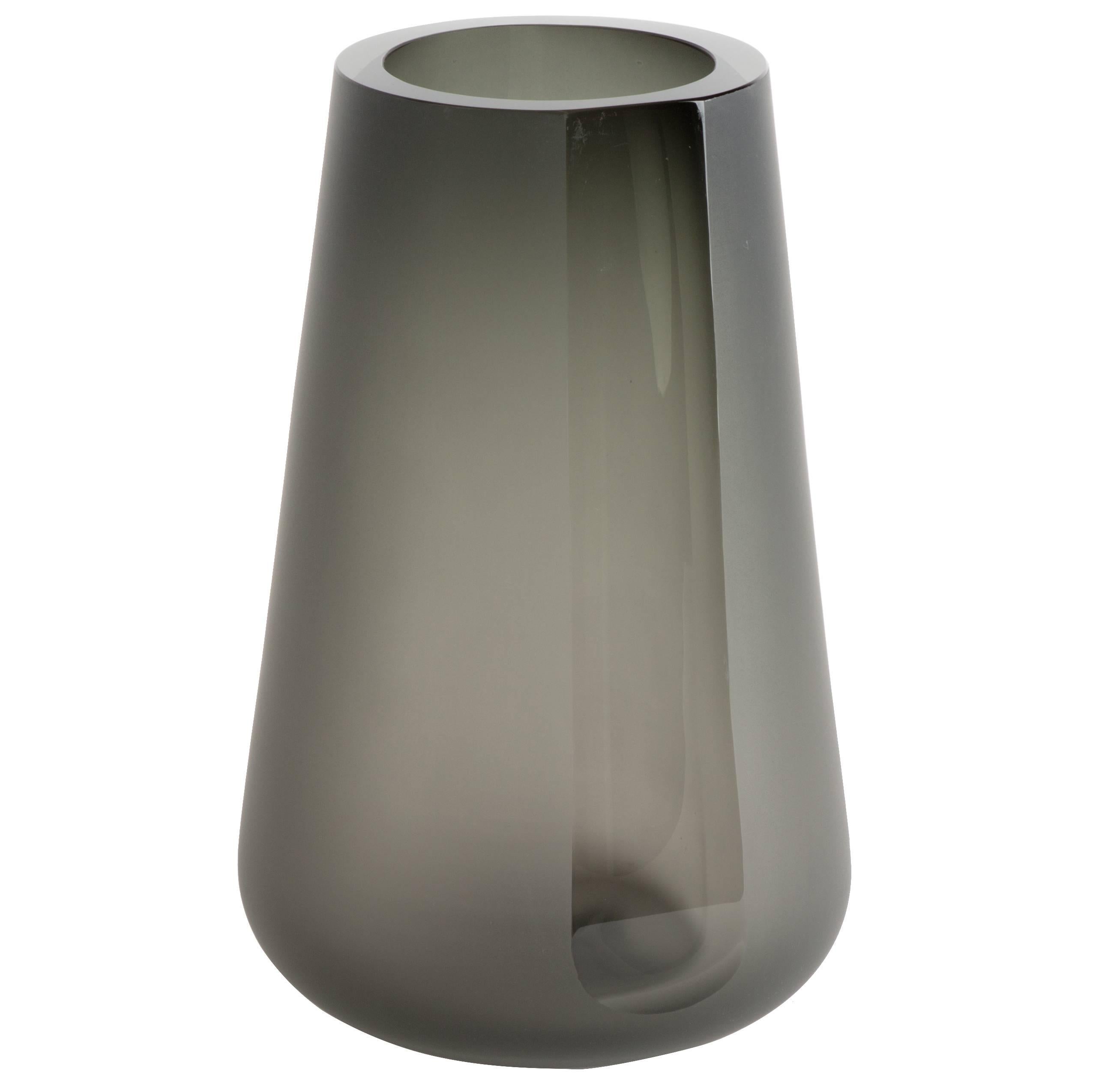 The Porto vase extra large is a simple exercise in optics and color. The smoke grey color and reflective light are diffused by a surface etching. A single panel, or 