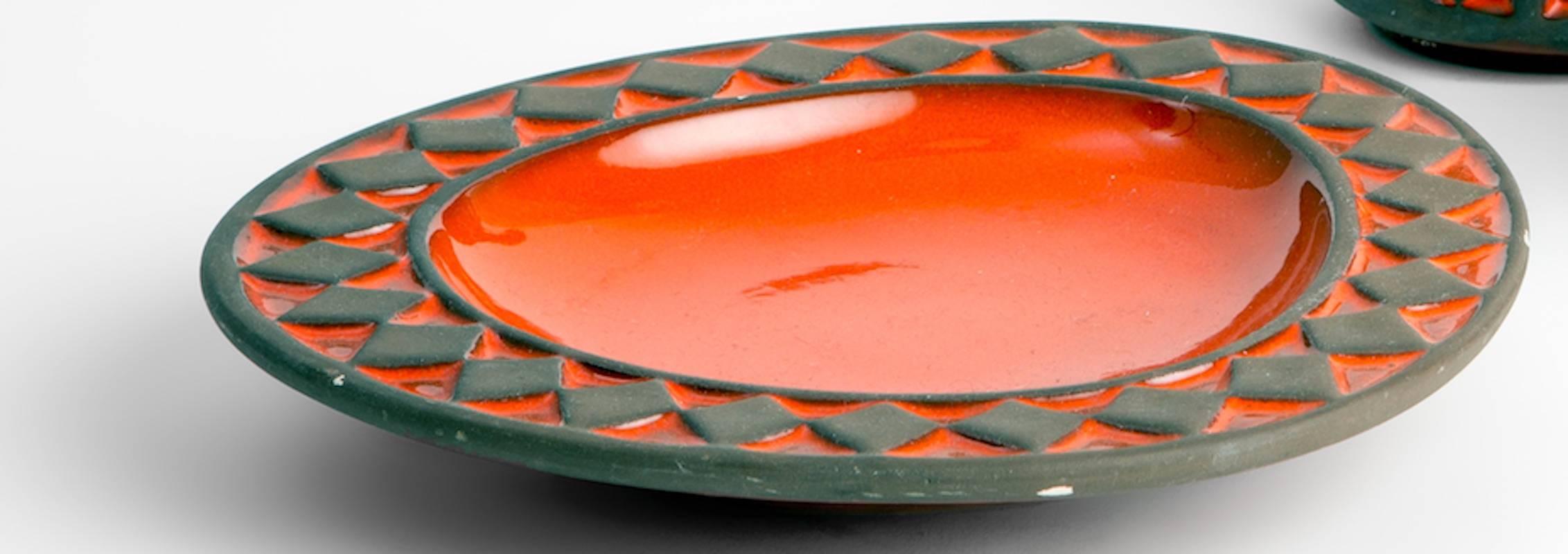 Set of three ceramics in a bright red/orange color with raised areas of un-glazed matte brown in bands/diamond pattern. With original sticker, 'Frank Keramik Denmark'

Measures: Plate: 8
