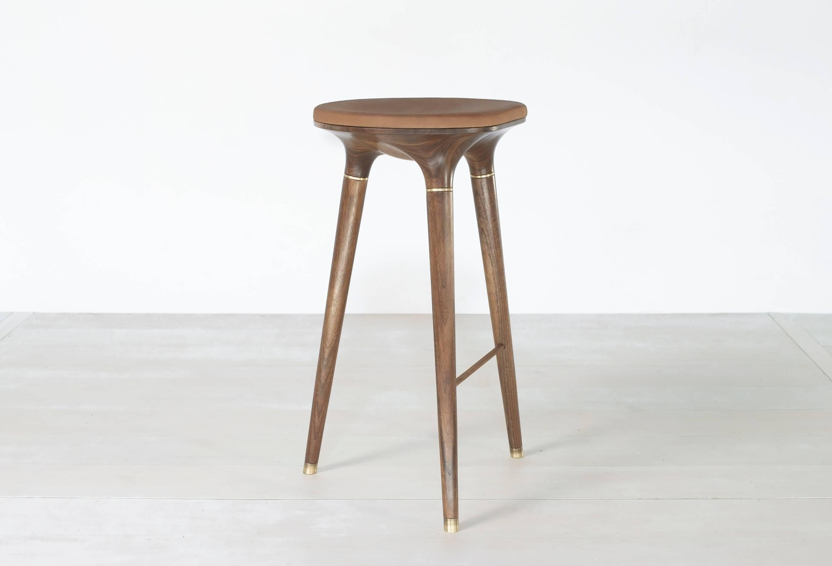 Natural finish Stool001 from series 001 by Vincent Pocsik.

Carved walnut stool with molded leather cushion top and brass accents. Shown here in a natural finish at bar height. 

Vincent Pocsik finds the balance between old and new fabrication