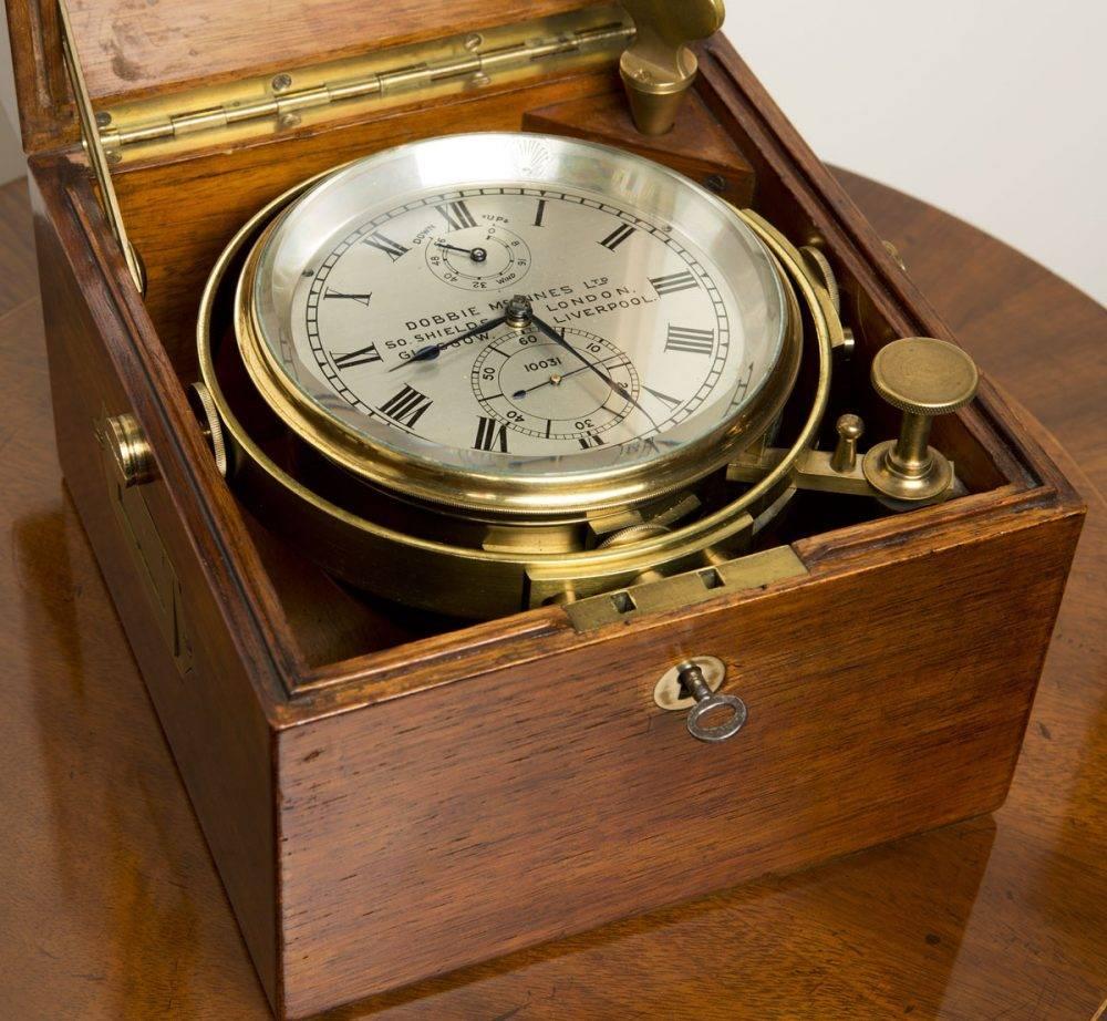 Marine chronometer by Dobbie McInnes No. 10031

Three-tier mahogany box with inset cartouche signed Dobbie McInnes Ltd 10031, Glasgow. Inset brass carrying handles, brass escutcheon to the base, ‘push button’ decorated brass knob opening the third