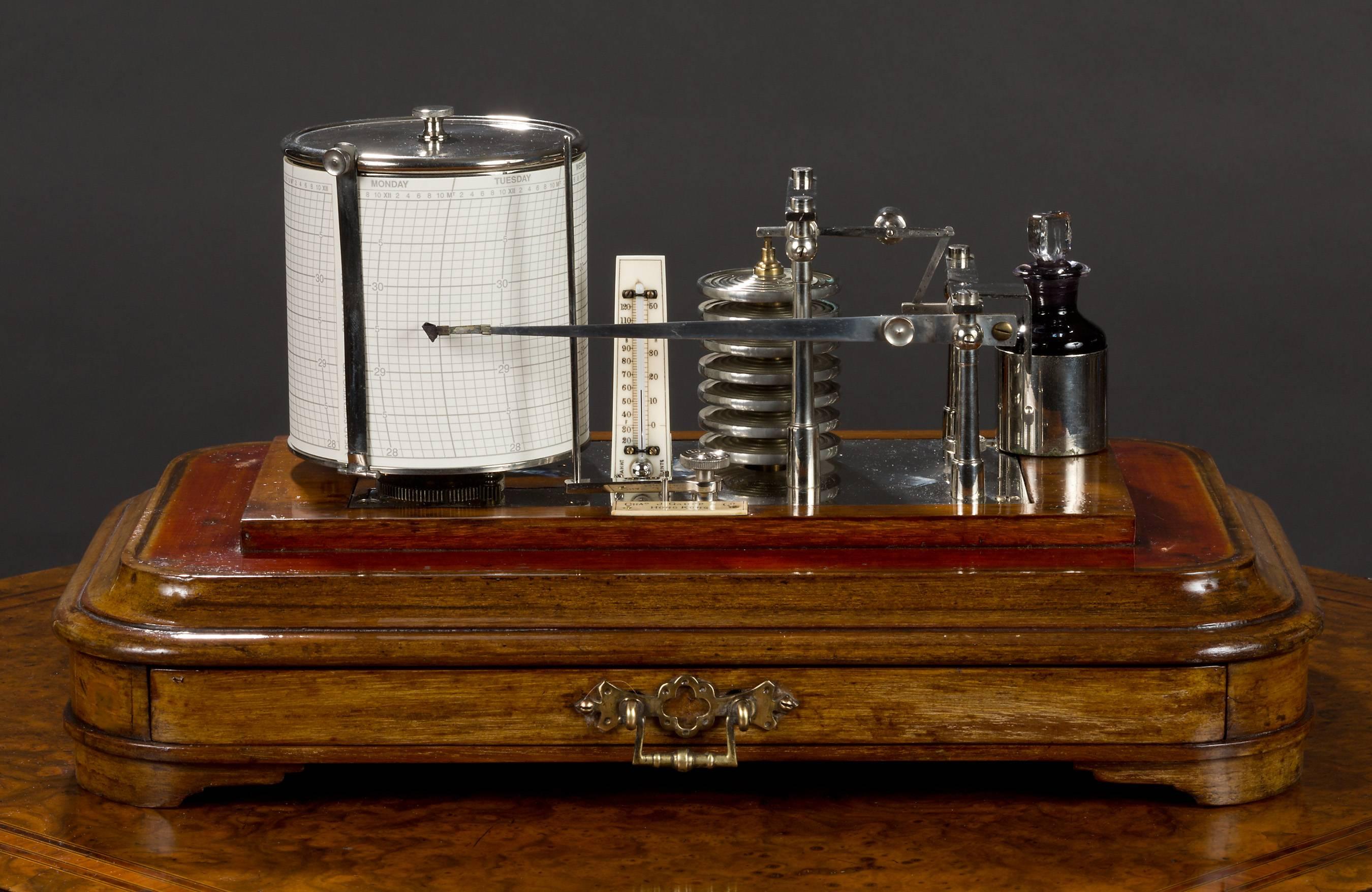Edwardian oak cased display barograph in a fine case standing on a raised plinth with ‘bracket’ feet and rounded corners. 

 Centrally mounted double chart drawer below the base which carries an ivory plaque signed ‘J.Gaupp and Co. Hong Kong’.