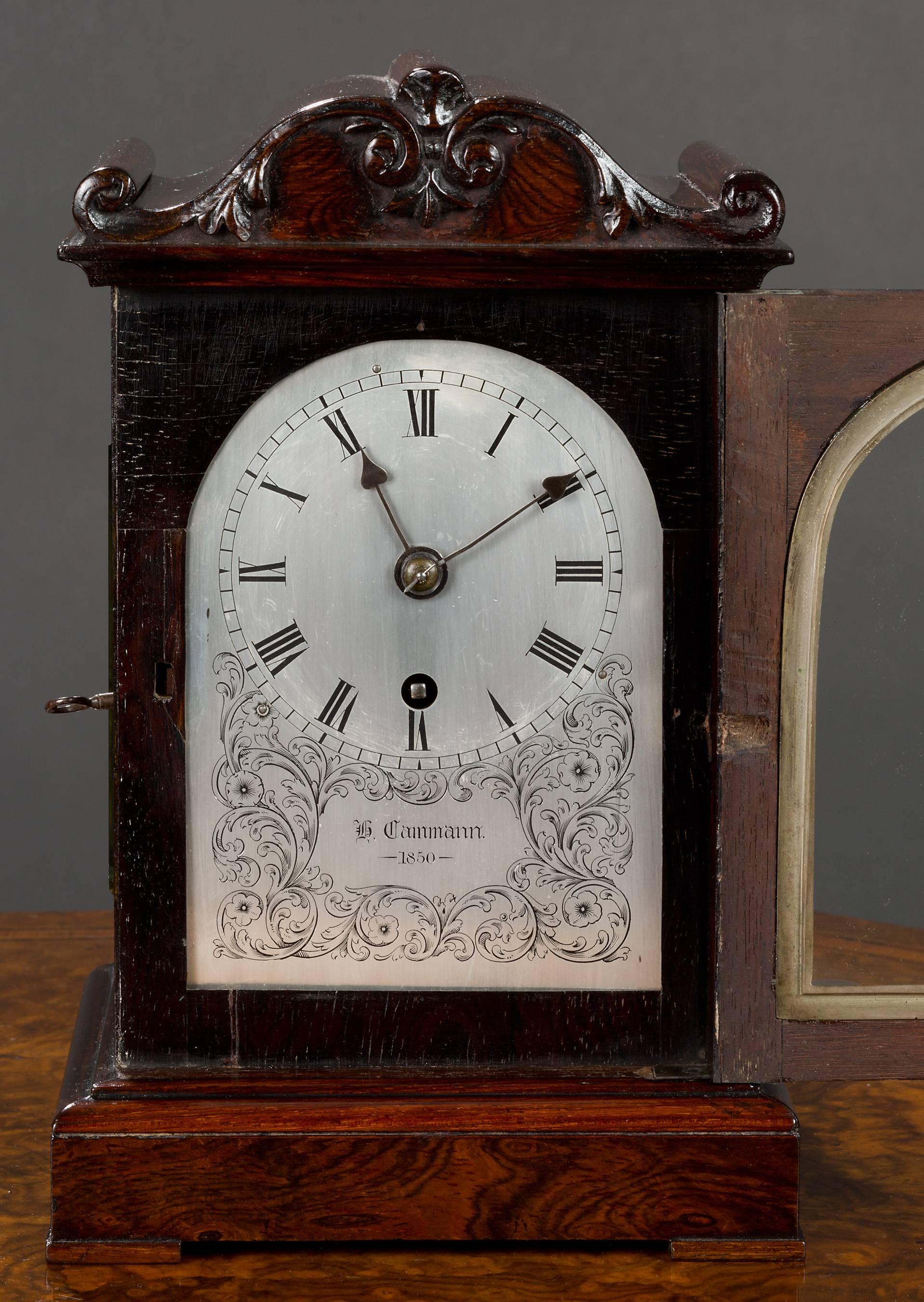 Victorian miniature rosewood bracket clock with applied carving to the scroll pediment, bevelled glass to the side viewing apertures and standing on a raised, moulded plinth with block feet. 

Beautifully engraved, silvered dial with Roman