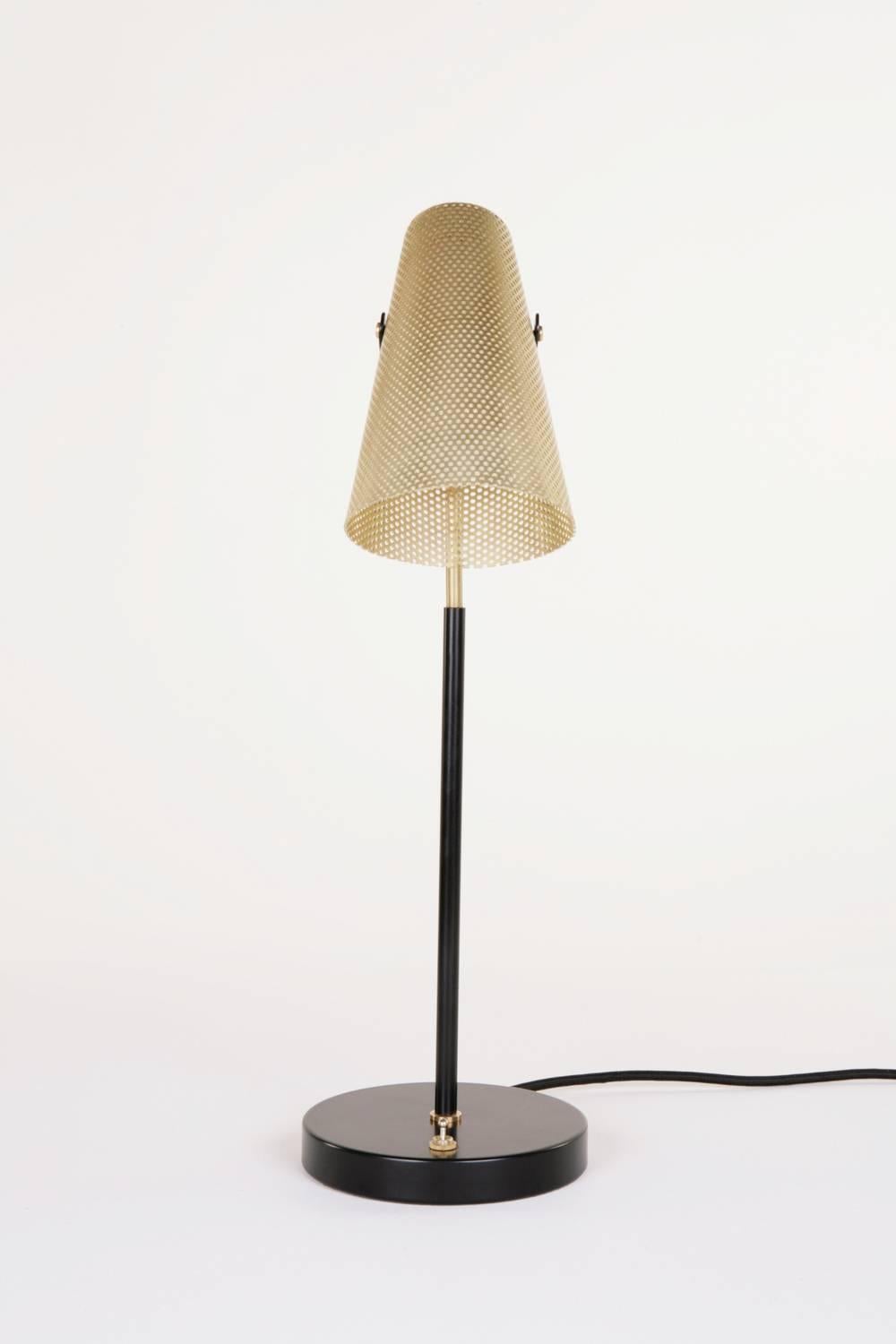 Inspiriert von der Schlichtheit der Sporen eines Pferdes, trägt die Lampe Eperon einen perforierten Messingschirm auf einem Messingstiel mit einem schwarz pulverbeschichteten Sockel. Diese einzigartige Schreibtischlampe bietet ein gerichtetes Licht,