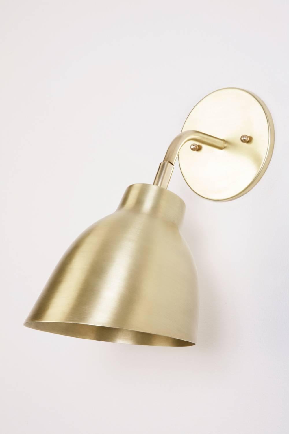 The Navire petite sconce is part of Atelier de Troupe's Classic Navire collection inspired by nautical lamps from the 1930s. It has a solid brass arm and up and down tilting shade. The sconce is hardwired and equipped with a 60W medium base