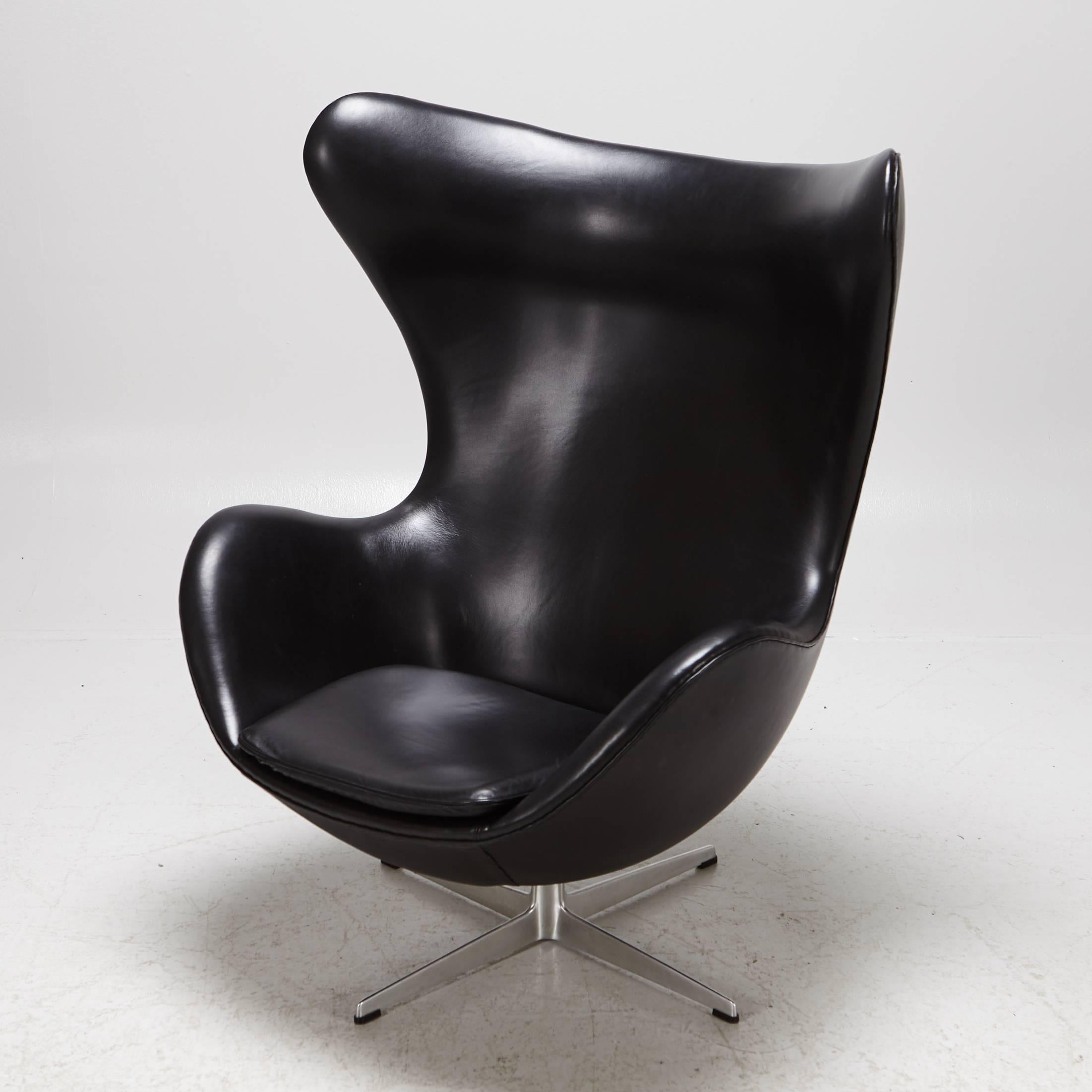 The iconic egg chair designed by Arne Jacobsen and manufactured by Fritz Hansen. This early edition of the chair features an aluminum frame with leather upholstery and the manufacturer's label.