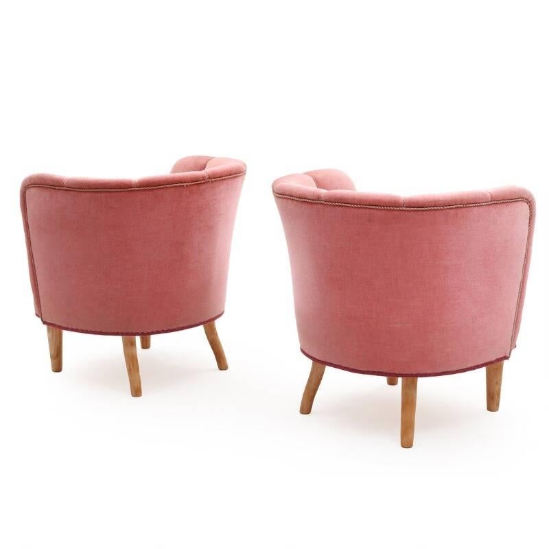 Danish furniture design: A pair of easy chairs with beech legs seat sides and back upholstered with pink velour, slightly curved rear legs, 1940s.