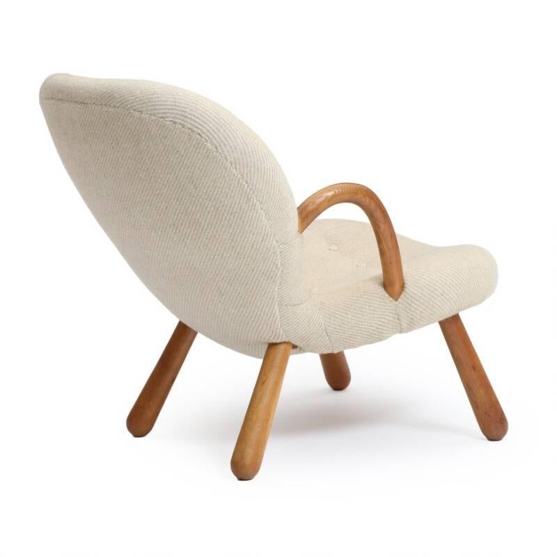 Easy chair with round oak armrests and legs, seat and back upholstered with light stribed button fitted wool. Designed 1944. Manufactured by Nordisk Staal- & Møbel Central, Denmark. Seat and back with light stribed wool.