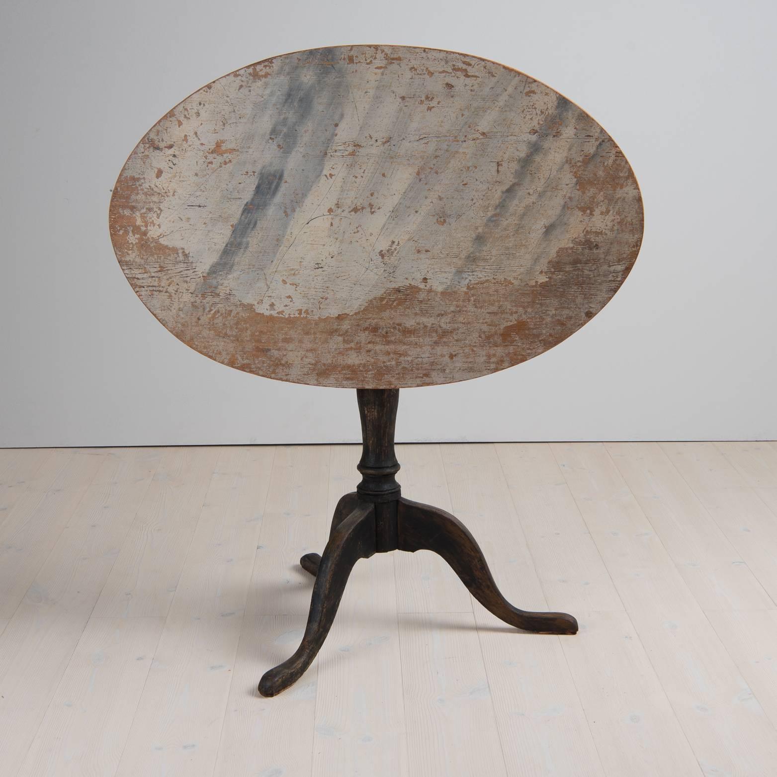 Swedish Rococo tilt-top table from Northern Sweden. Oval top with a turned base standing on a tripod foot. The table is dry scraped to original paint. No touch ups.