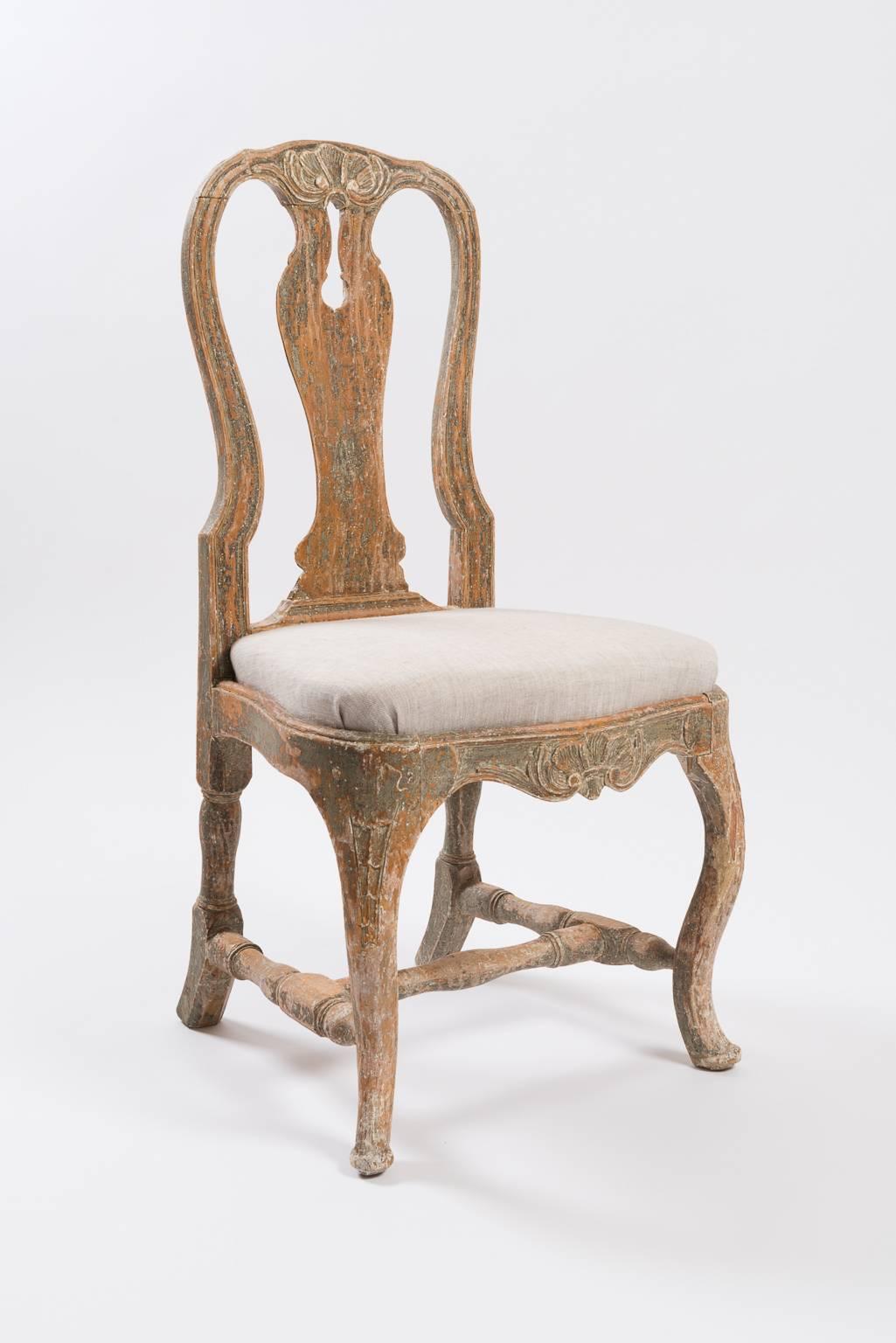 A pair of Swedish Rococo chairs with nice proportions and wooden Rococo carvings. Scraped to original paint and original seats with new linen. Manufactured in Stockholm, Sweden, circa 1760.