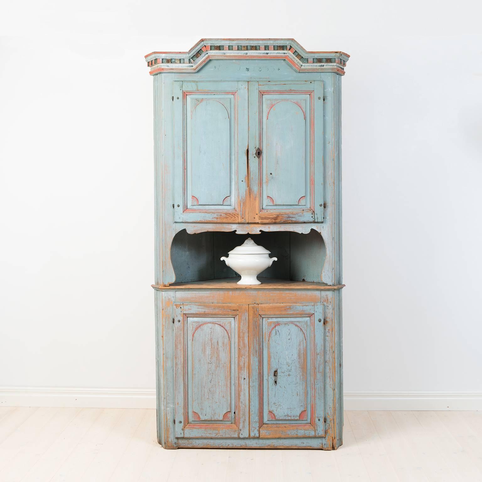 Charming Folk Art corner cupboard from northern Sweden with dating 1853. The cabinet is completely untouched and still has its natural patina from the 1800s. Two-pieced.