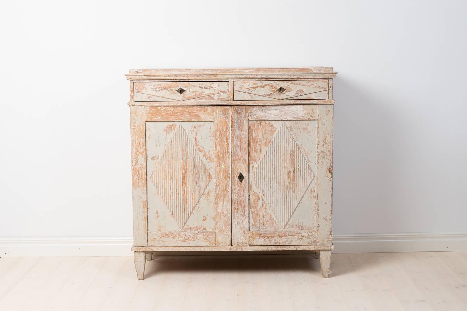 Period Gustavian sideboard with ribbed decor on doors and drawers. Paint, locks and hardware are all original to the sideboard - from the 1780s. Unusually tall legs.