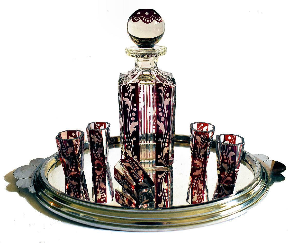 Very attractive Art Deco decanter set still retaining it's original label. With ruby colored enamel decoration and clear glass this lovely set oouzes quality. Please note the tray show is for demonstration purposes and isn't included in this sale.