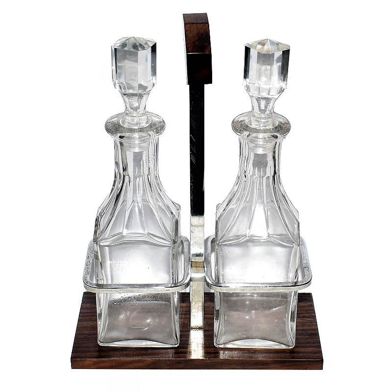Very much in the style of Jacque Adnet is this wonder 1930s Art Deco condiment set. The wooden base is a lovely exotic palisander, part of the Rosewood family. A simple chrome frame holds two glass bottles for oils and vinegar. Lovely set in