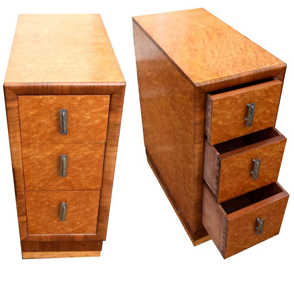 Fabulous pair of matching 1930s Art Deco bedside tables in blonde bird's-eye maple veneer with walnut feather banding to the edges. Three generously sized drawers to each cabinet all of which retain their original filigree handles. Each drawer pulls