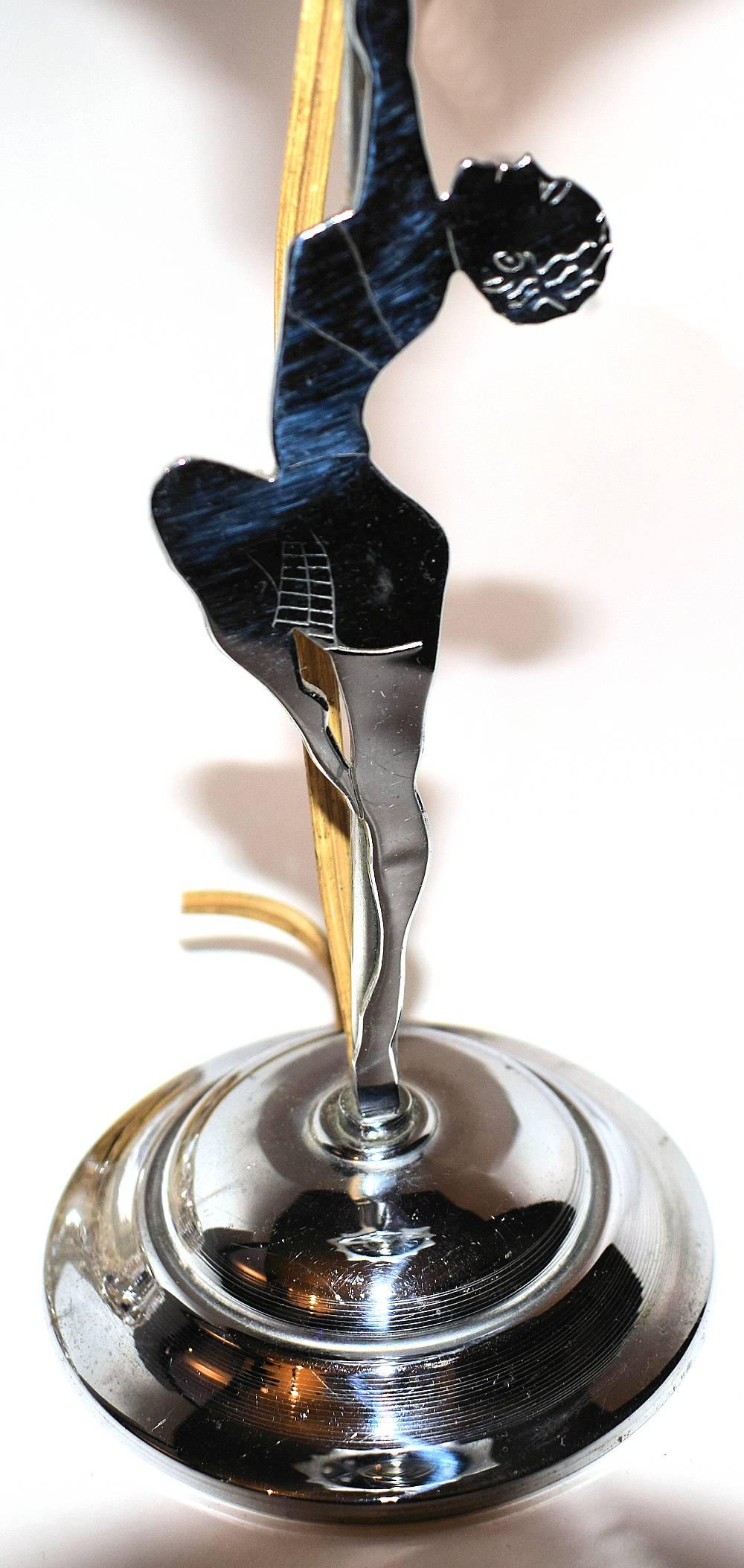 Nous vous présentons cette superbe et originale lampe Art Déco chromée des années 1930 représentant une dame posée en deux dimensions avec un rare abat-jour en verre de gratte-ciel à effet givré. Originaire d'Angleterre. Ces lampes sont de plus en