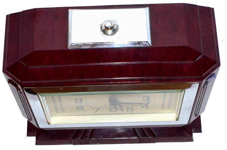 One of the more rare Bakelite French clocks we have in stock. This clock has a wonderful Bakelite case design. The bezel is mirror chrome, the Bakelite is a deep mottled red with flecks of black. A silvered dial and stylized Art Deco numerals finish