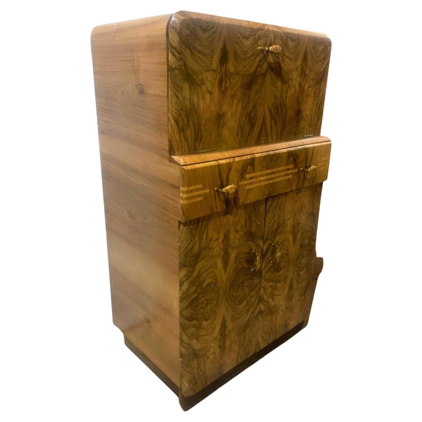 For your consideration is this fabulously stylish 1930's Art Deco cocktail cabinet. This dry bar dates to the 1930's and has all the bells and whistles you want from a cocktail cabinet. The upper interior has a mirrored base and mirrored backing .
