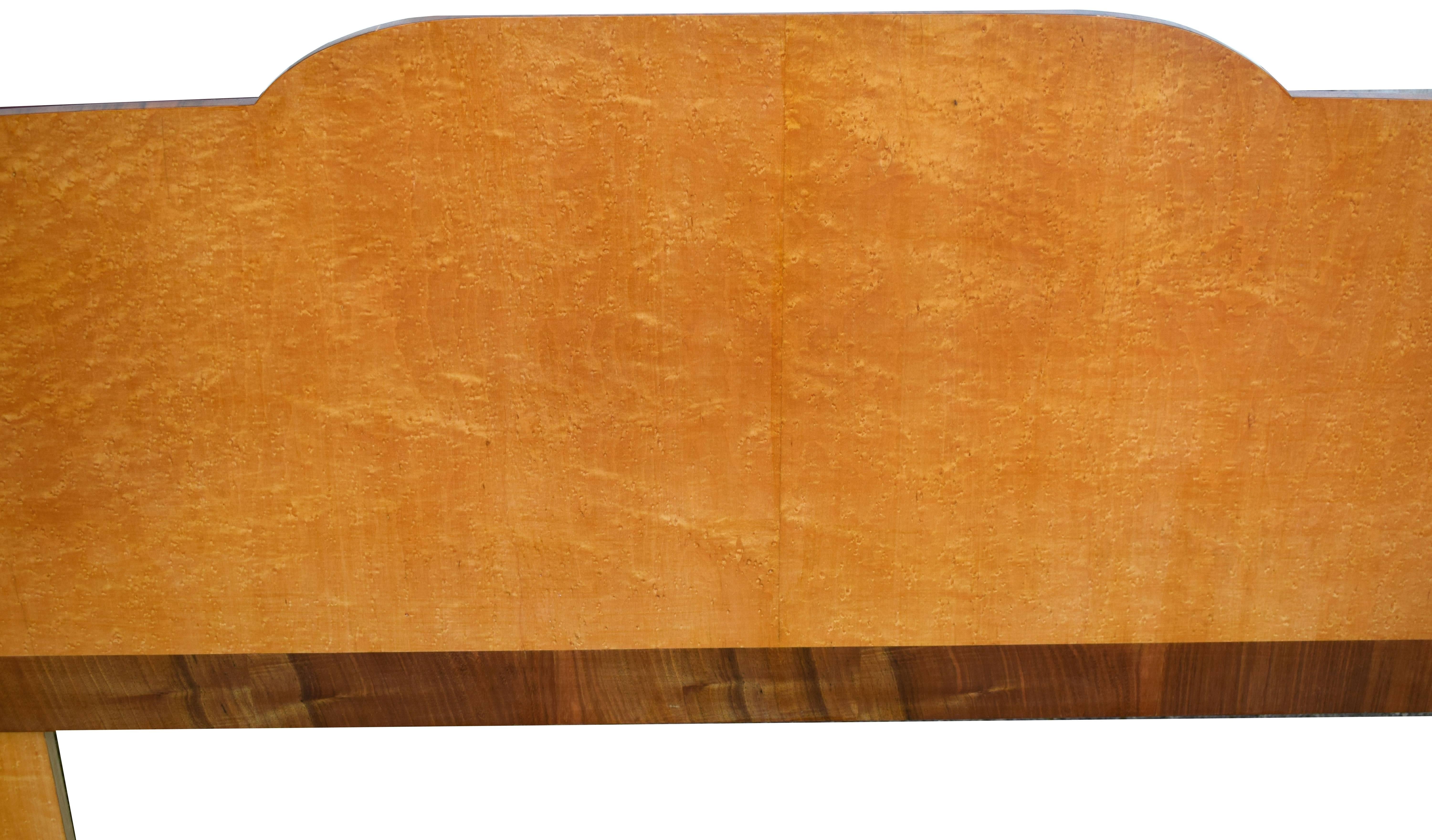 Wonderfully stylish and so indicative of this bygone era is this Art Deco 1930's double bed. Veneered in bird's-eye maple with walnut feather banding to accentuate the cabinets with an over-all odeon or cloud shape. The blonde colouring would easily
