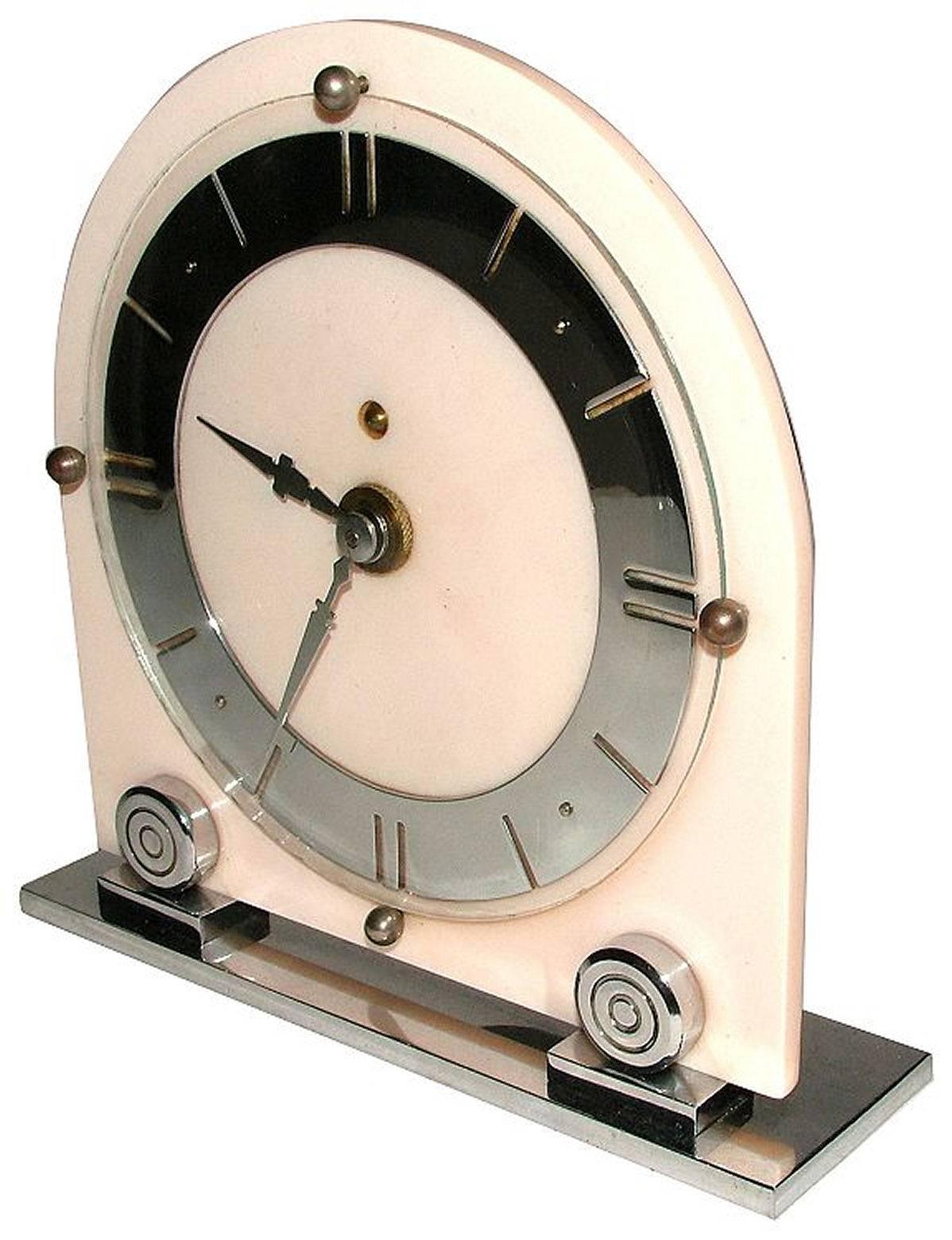 Stylish Art Deco mantel piece clock by LS Mayer in good working order. Modernist dial and stylised chrome detailing. Background is the palest of pinks in an early plastic and bakelite. Condition is excellent, the chrome is as bright as crisp as when