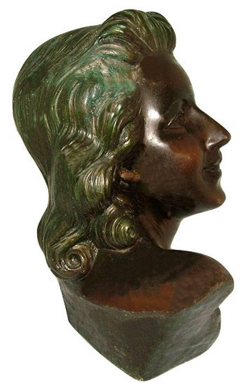 A really lovely French, Art Deco bust of very high quality. She's lifesize and shows the profile of a young Parisian woman with a victory roll hairstyle she excludes glamour. She's made from hollowed plaster and cold painted on top, wonderful bronze