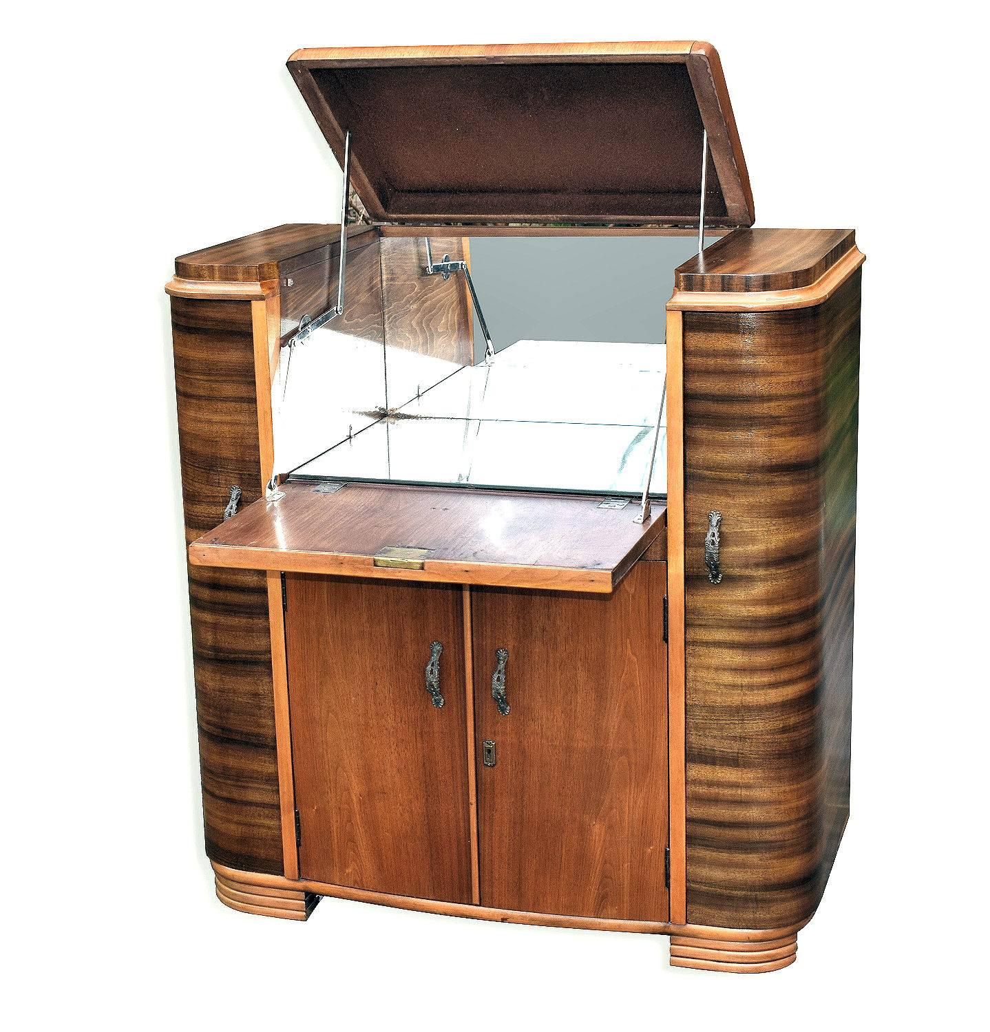 This really is a wonderful cocktail cabinet; the shape is superb and reminds of the old 1930s radiogram cabinets. Two contrasting walnut veneers, English and Australian. Typically of these cabinets the top opens up to reveal a mirrored interior,