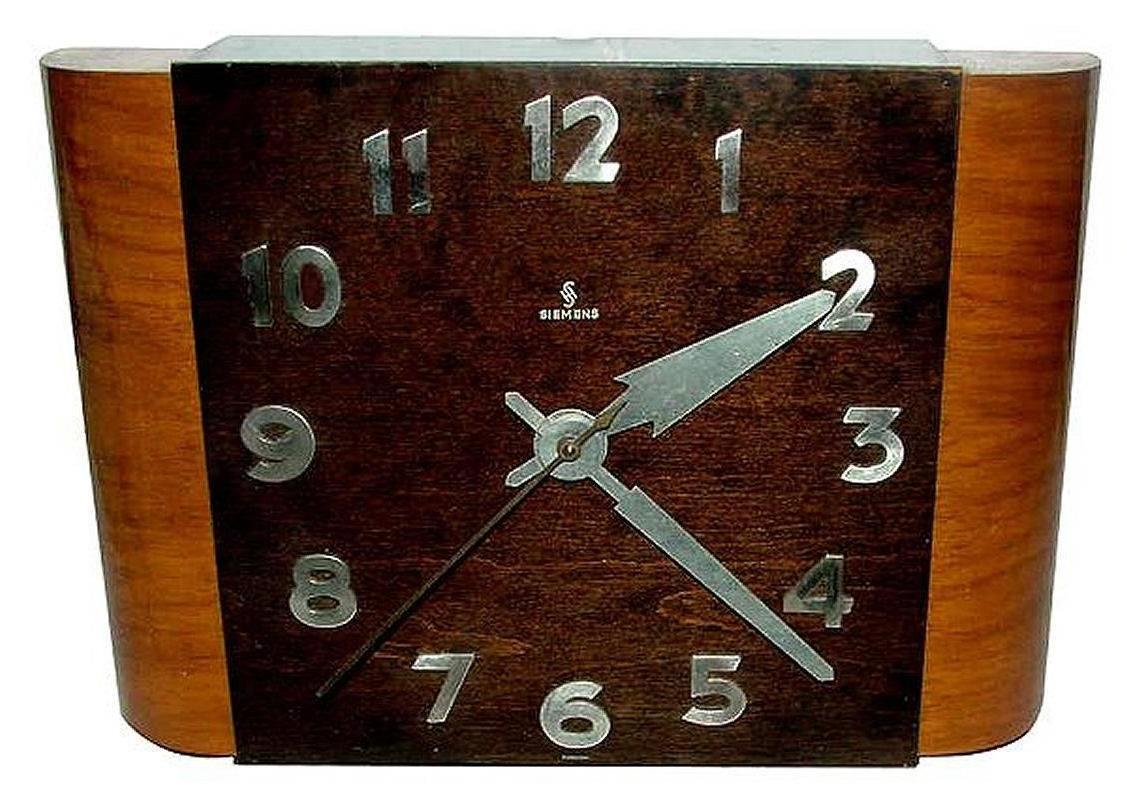 1930s Art Deco wall clock manufactured by Siemens company. This lovely piece is made from beautiful warm oak and the dial a more dark oak which accentuates the lovely chrome Art Deco numerals very nicely. The case side pieces have a stylised