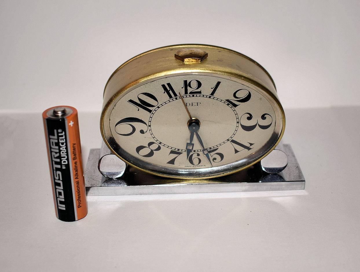 This truly is a delightful and very stylish Art Deco clock of small proportions, please see further pics the battery is to demonstrate size only. Wonderful oval dial incased in a polished brass case and supported on a chrome plinth. The numerals to