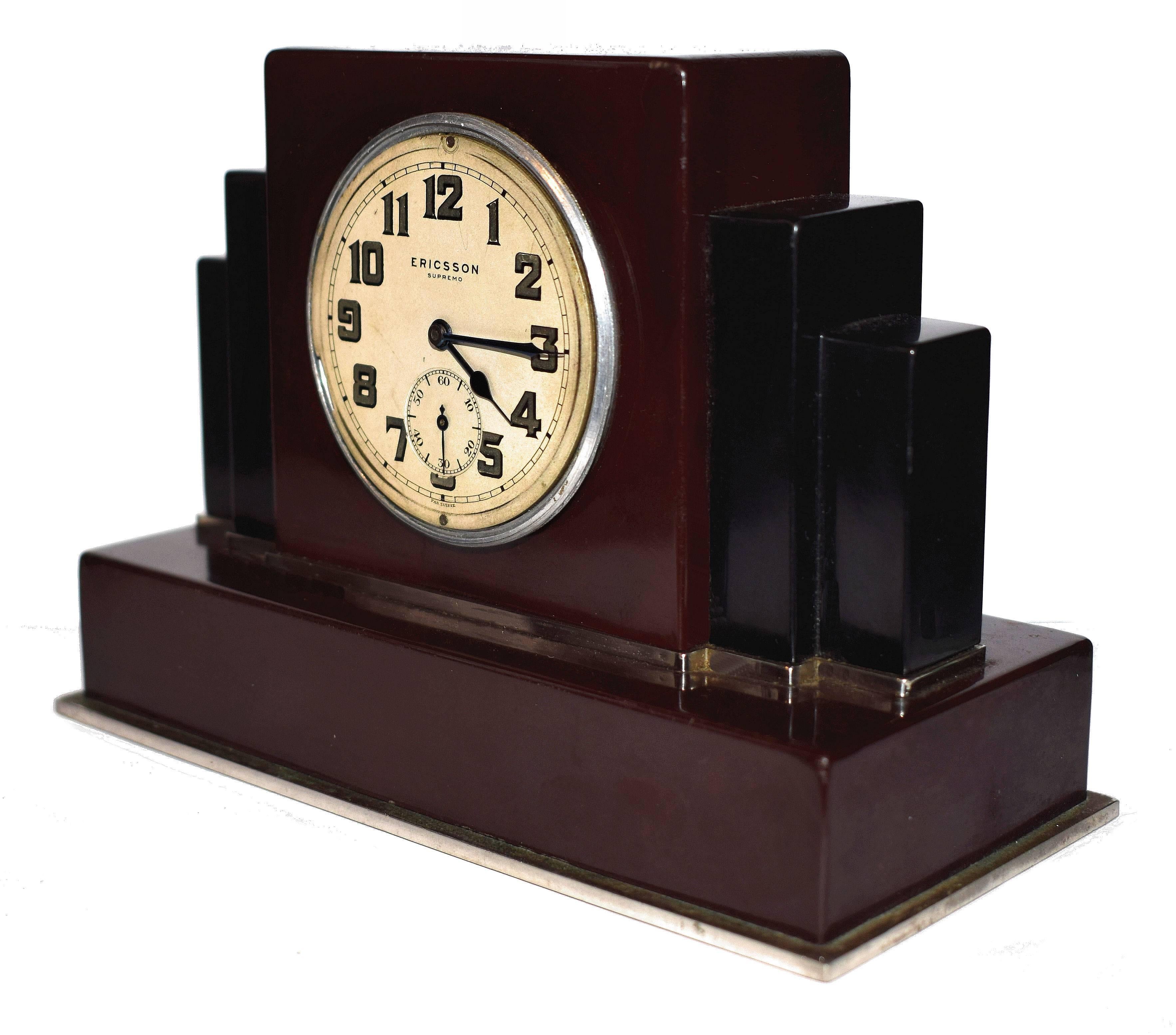 Superb 1930s Art Deco bakelite clock by the Swiss clock makers Ericsson. Very stylish and iconic bakelite case with stepped or skyscraper shape. The bakelite is deep red and black with chrome trim accent around the base and second-tier. This is a