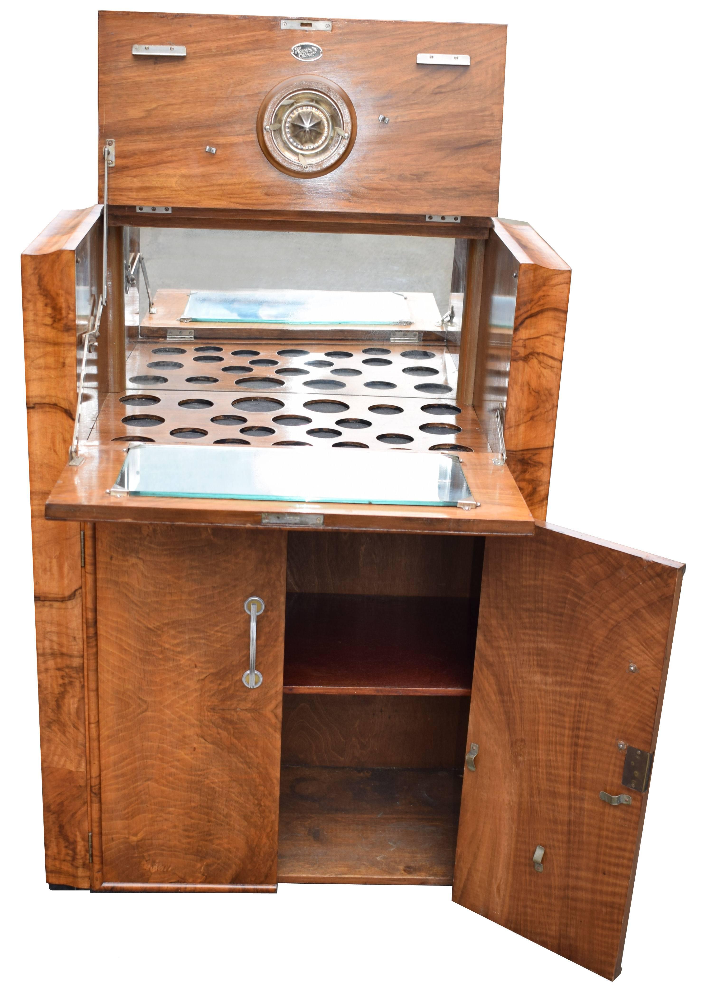 Beautiful 1930s Art Deco walnut upright cocktail cabinet, every deco interior should have one of these ! Features a drop down top which reveals a mirrored interior and storage for bottles and glasses. A generously sized cupboard below offers plenty