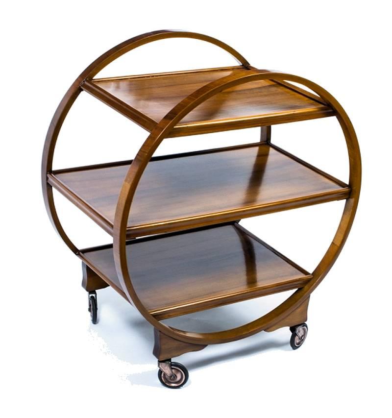 Very attractive and iconic English Art Deco Hostess trolley cart dating from the 1920s-1930s period. This three tiered trolley not only looks awesome but is very functional too. Veneered in a mid tone walnut with original fully functioning casters.