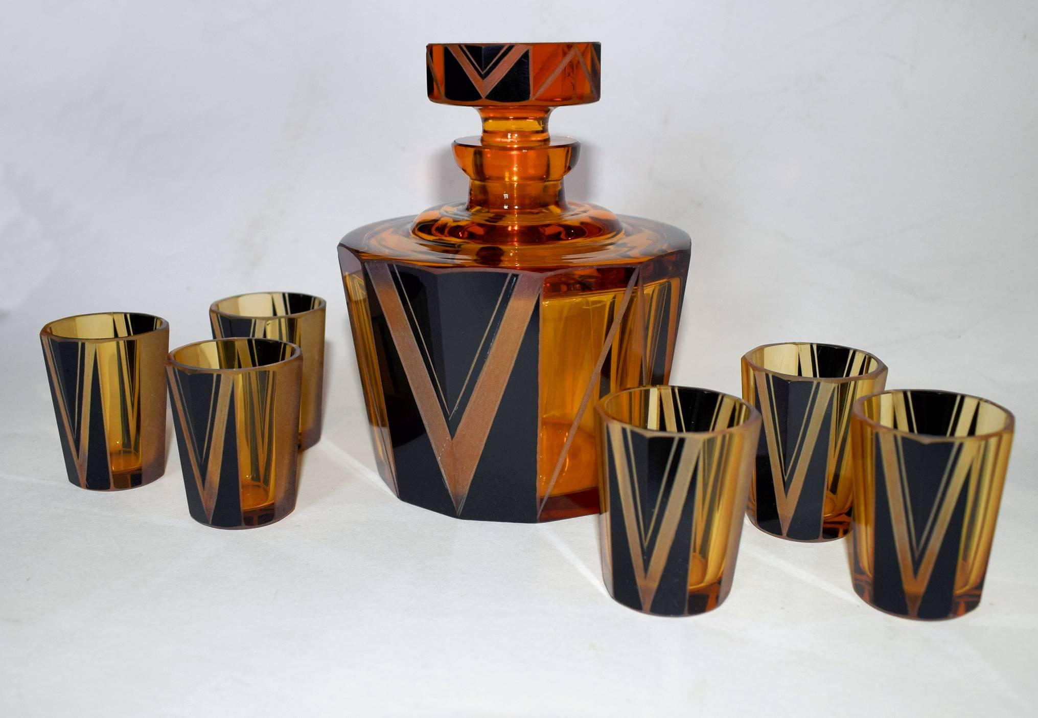 Wonderfully stylish 1930s Art Deco glass decanter set in a warm amber color with black geometric enamel decoration. Originates from the Czech Republic. This wonderful set is deceptively heavy and shows signs of real quality. The whole set is in