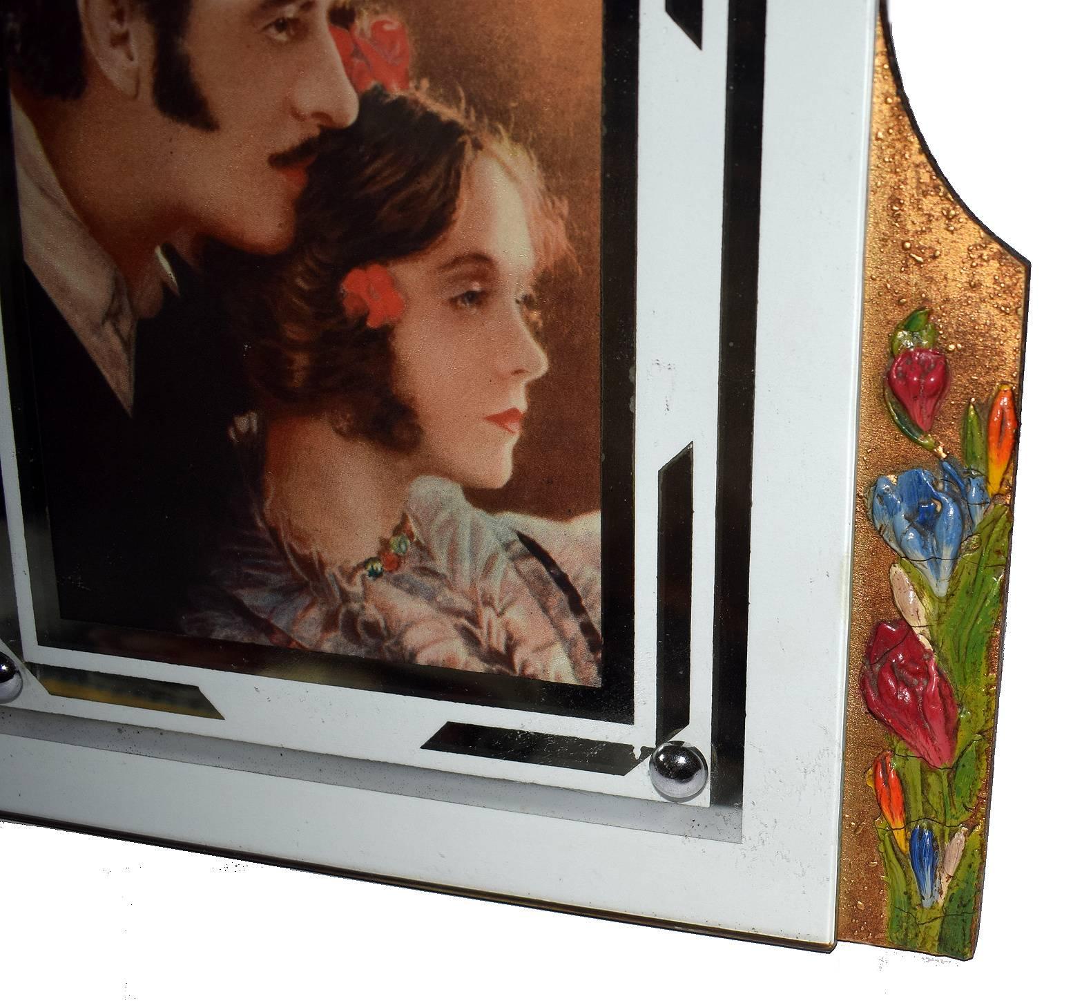 This delightful Art Deco Barbola picture frame features traditional vintage style floral motifs which are further enhanced by the natural colour palette. The central glass frame has a mirrored geometric motif design. Original gilded backing which