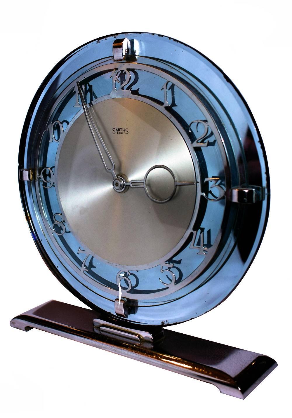 Very attractive 1930s Art Deco Modernist clock. Mechanical movement and keeps very good time. Features a lovely blue tinted mirrored dial face with gilt numerals and hands all of which is supported on a resting chrome plinth. Condition is way above